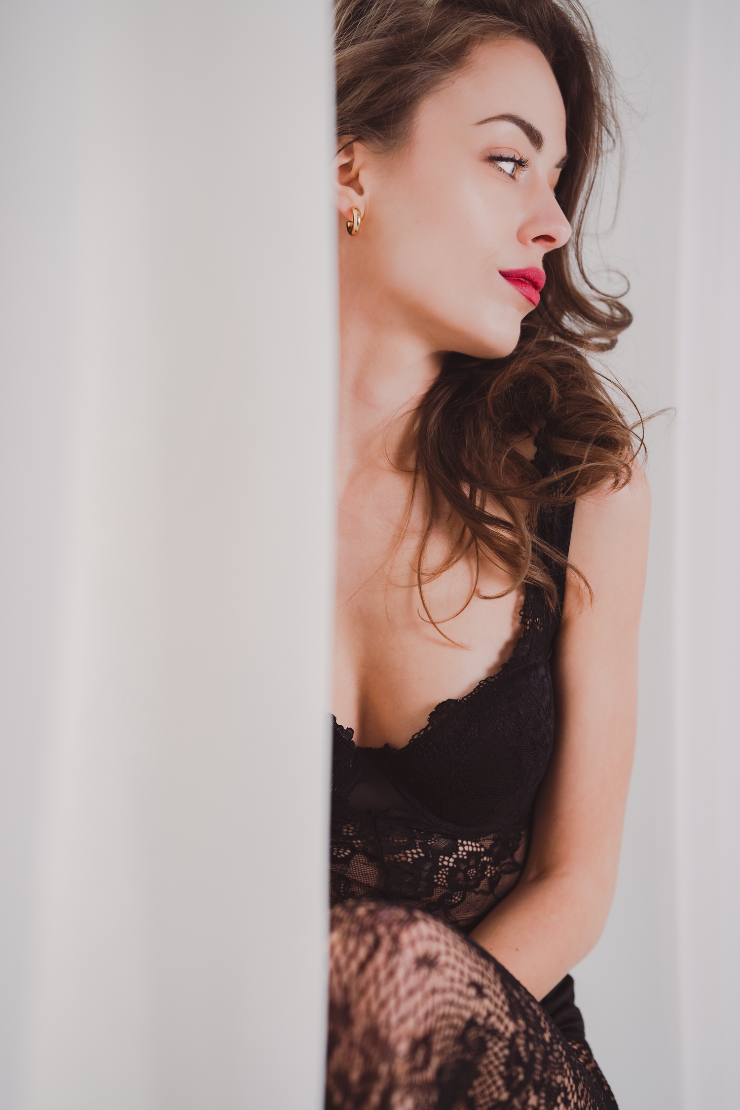 Elegant boudoirserie i svart spets med graciösa poser mot vit bakgrund.