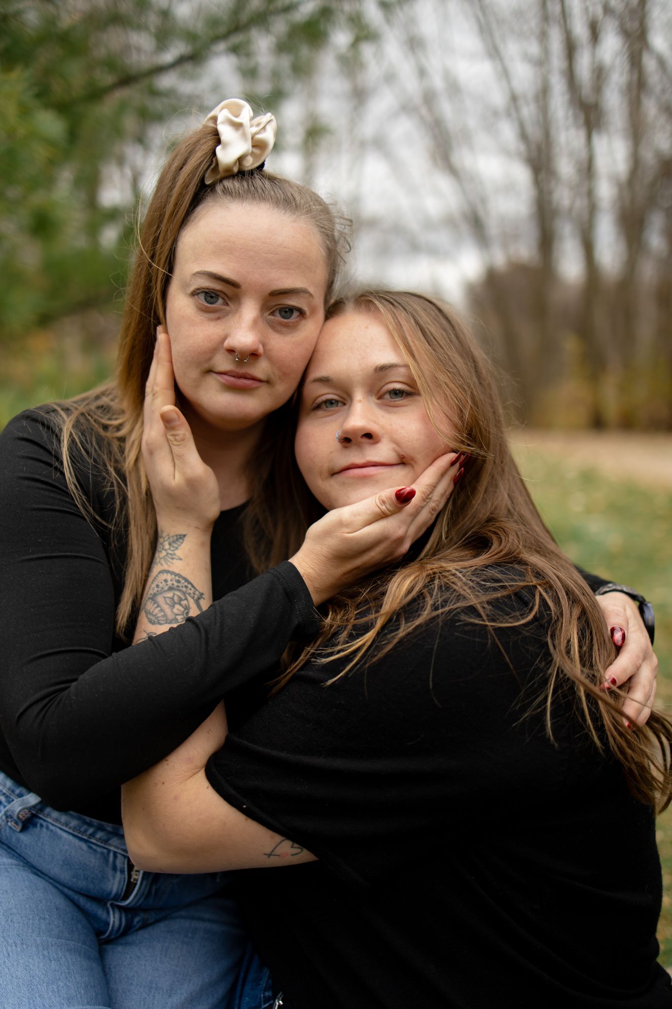 Two people in casual wear share playful moments outdoors on an overcast day.