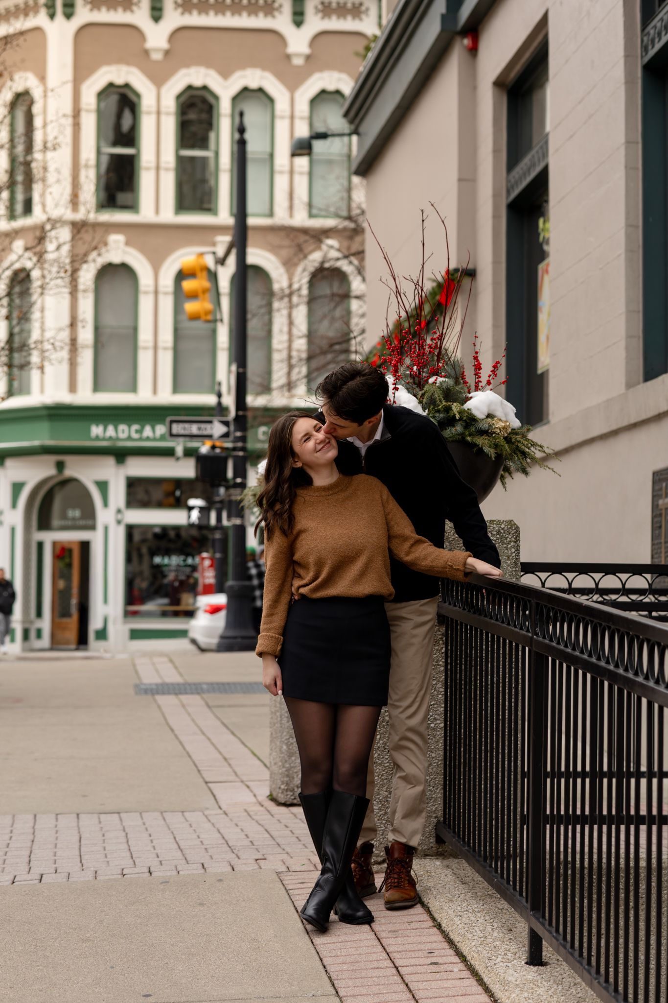 Urban engagement photo series with couple posing along city railings.