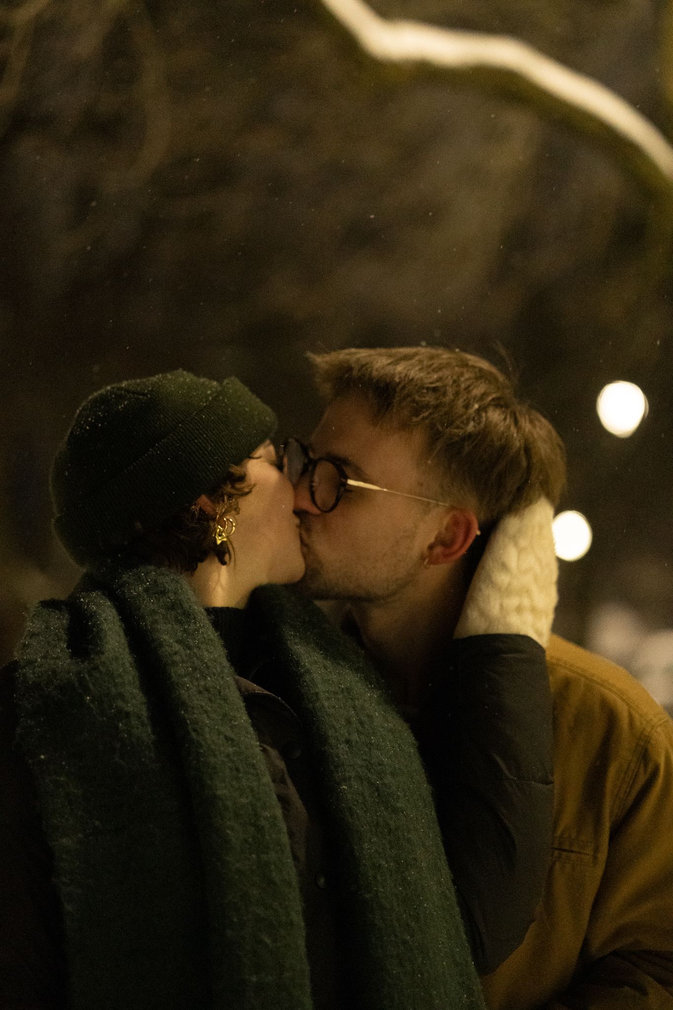 A tender moment shared between two people on a snowy winter night.