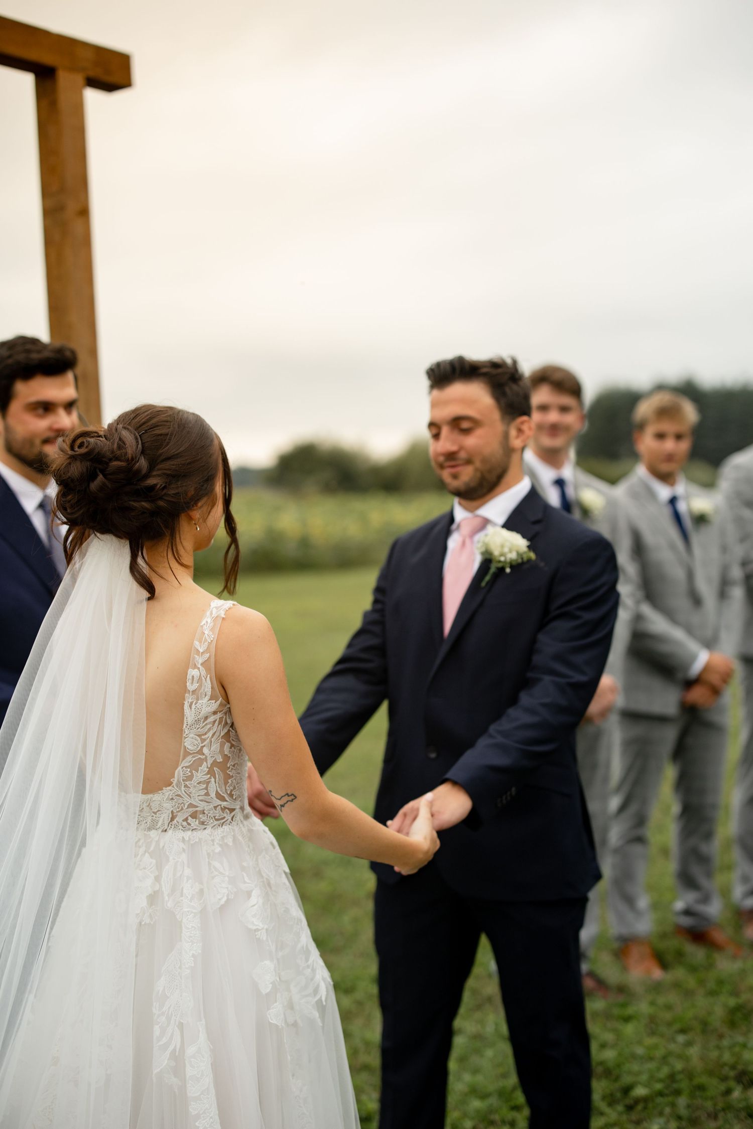 Wedding party members standing in a line during an outdoor ceremony.