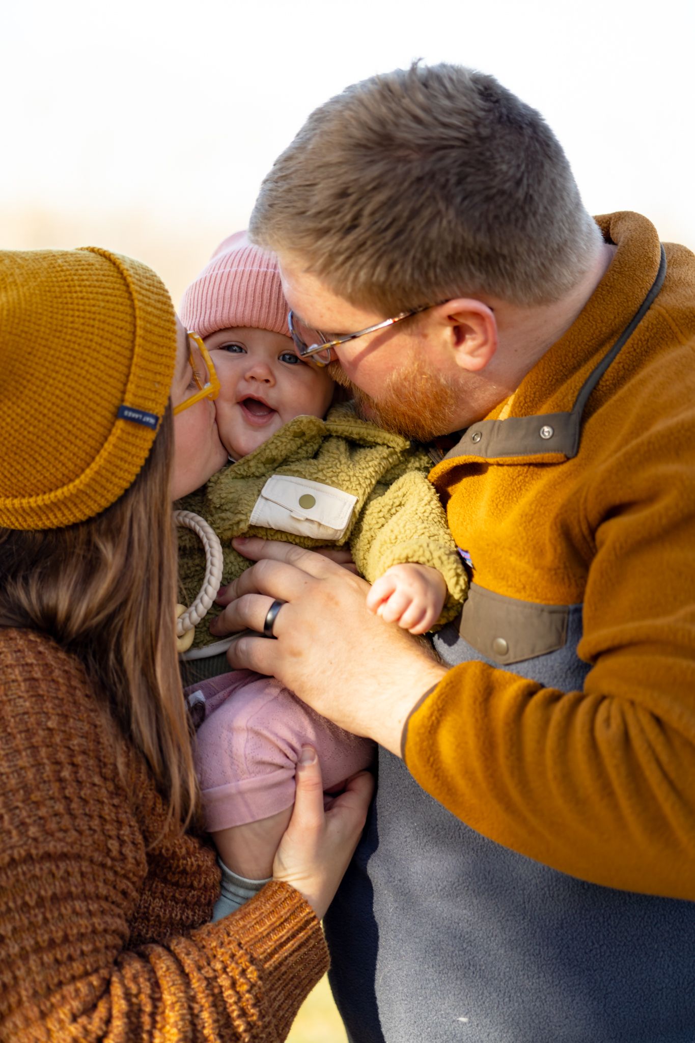 Two people share an intimate moment while wearing warm fall clothing in a cozy indoor setting.