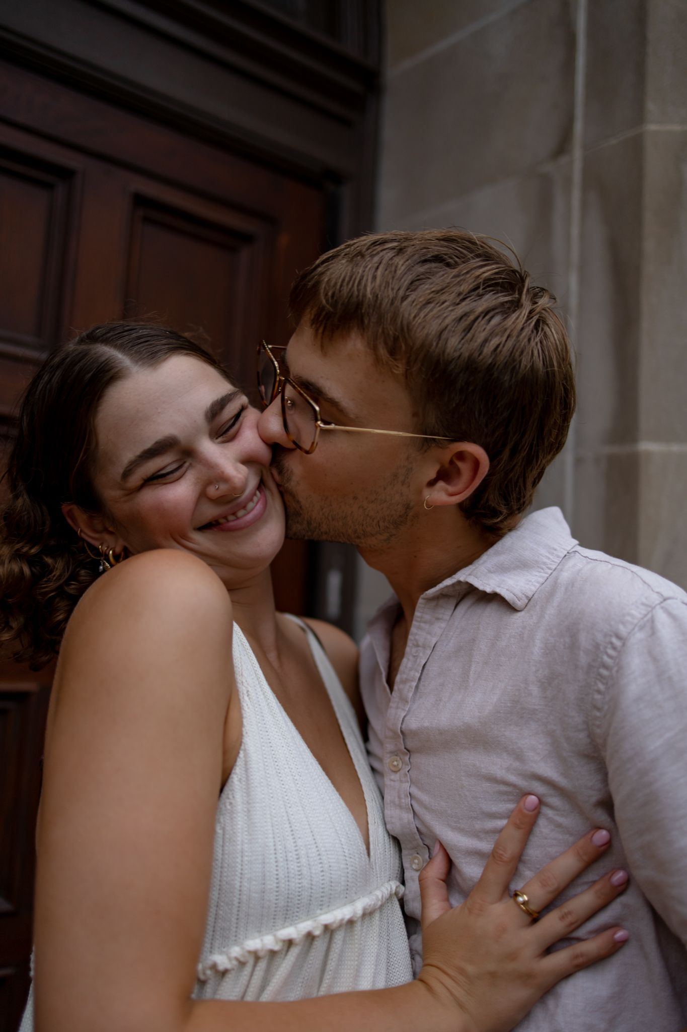 A tender romantic moment shared between a couple against a historic doorway.
