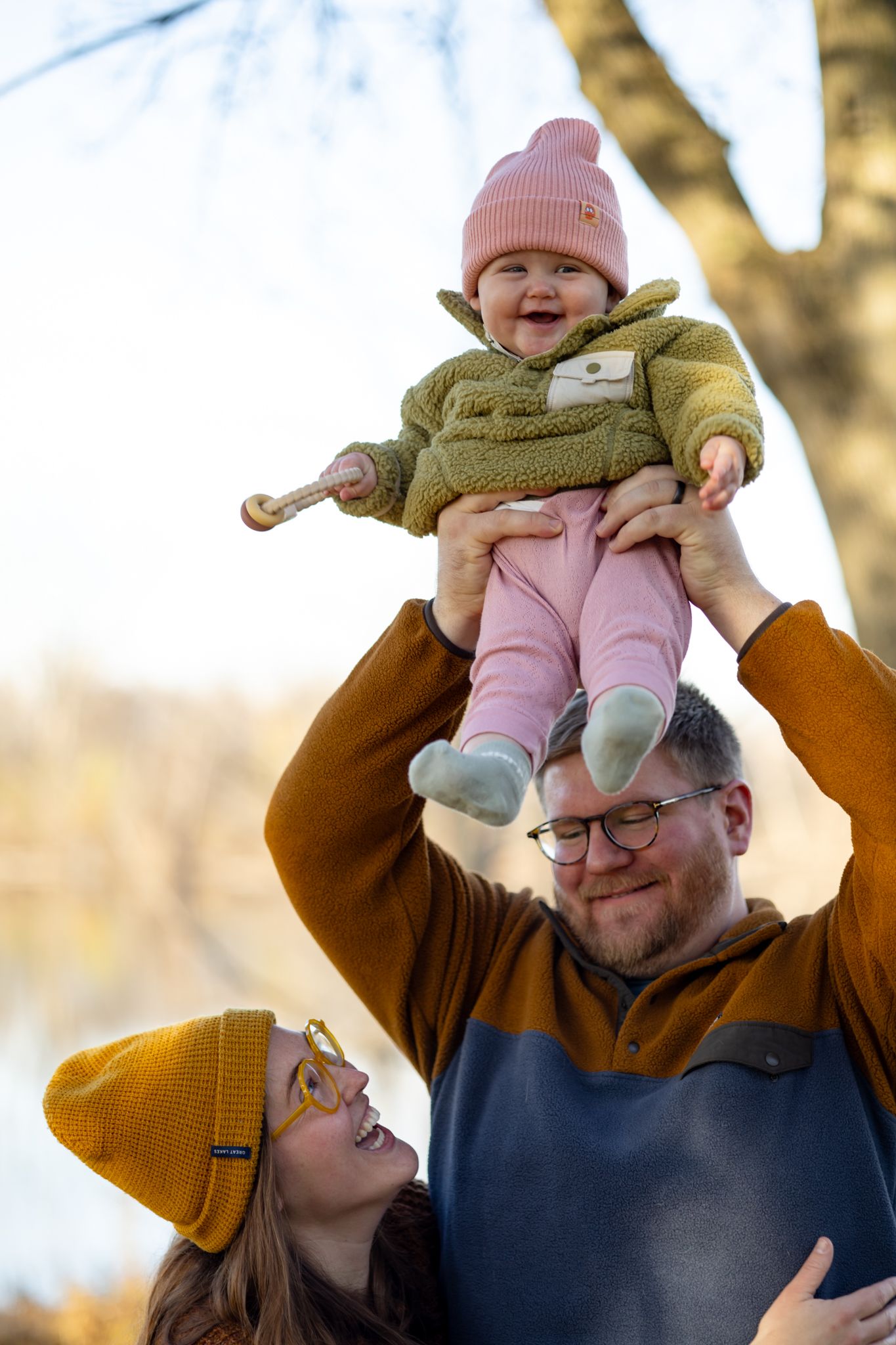 Family sharing a joyful winter moment outdoors wearing warm clothing.