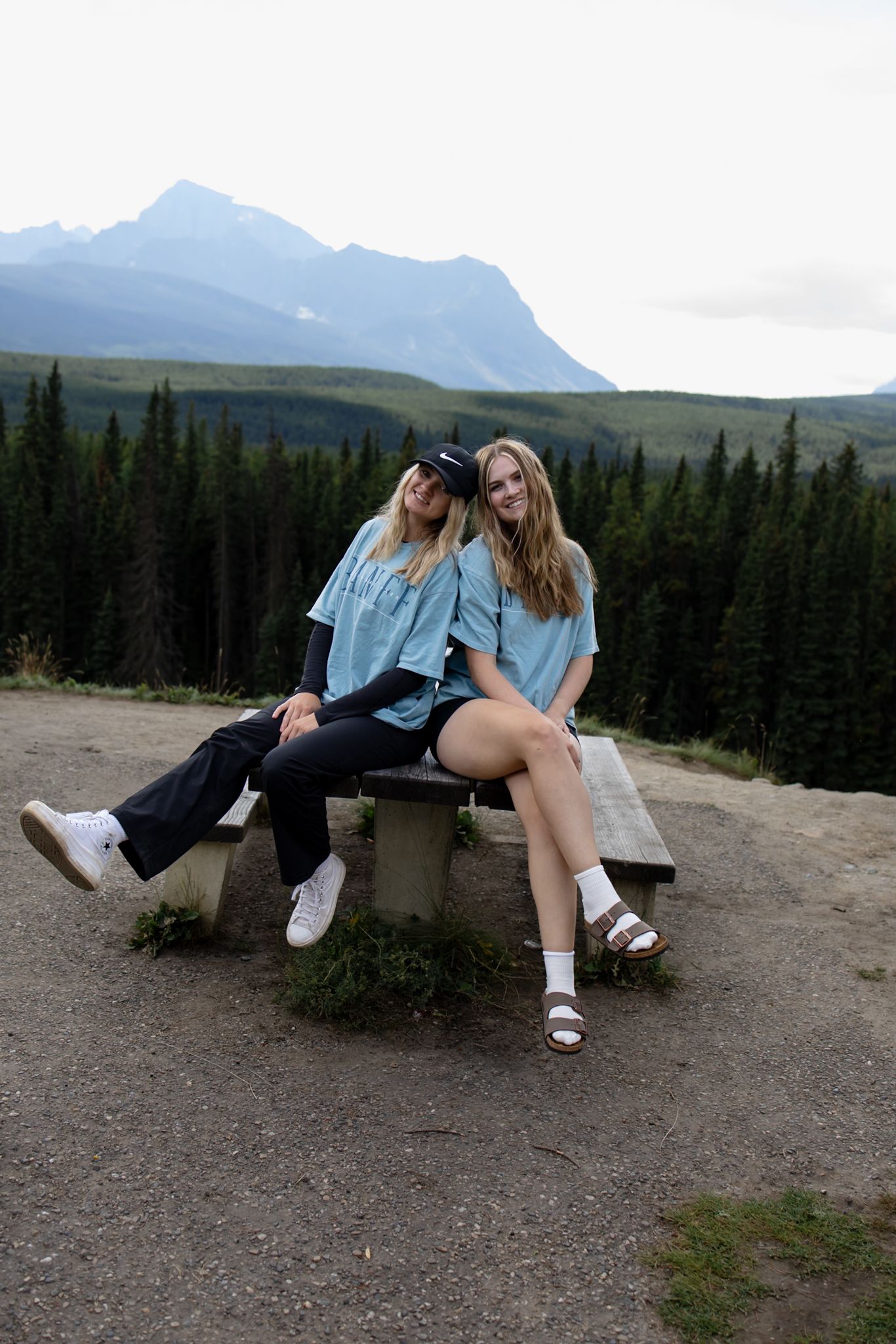 People resting on a rocky overlook with mountain views.