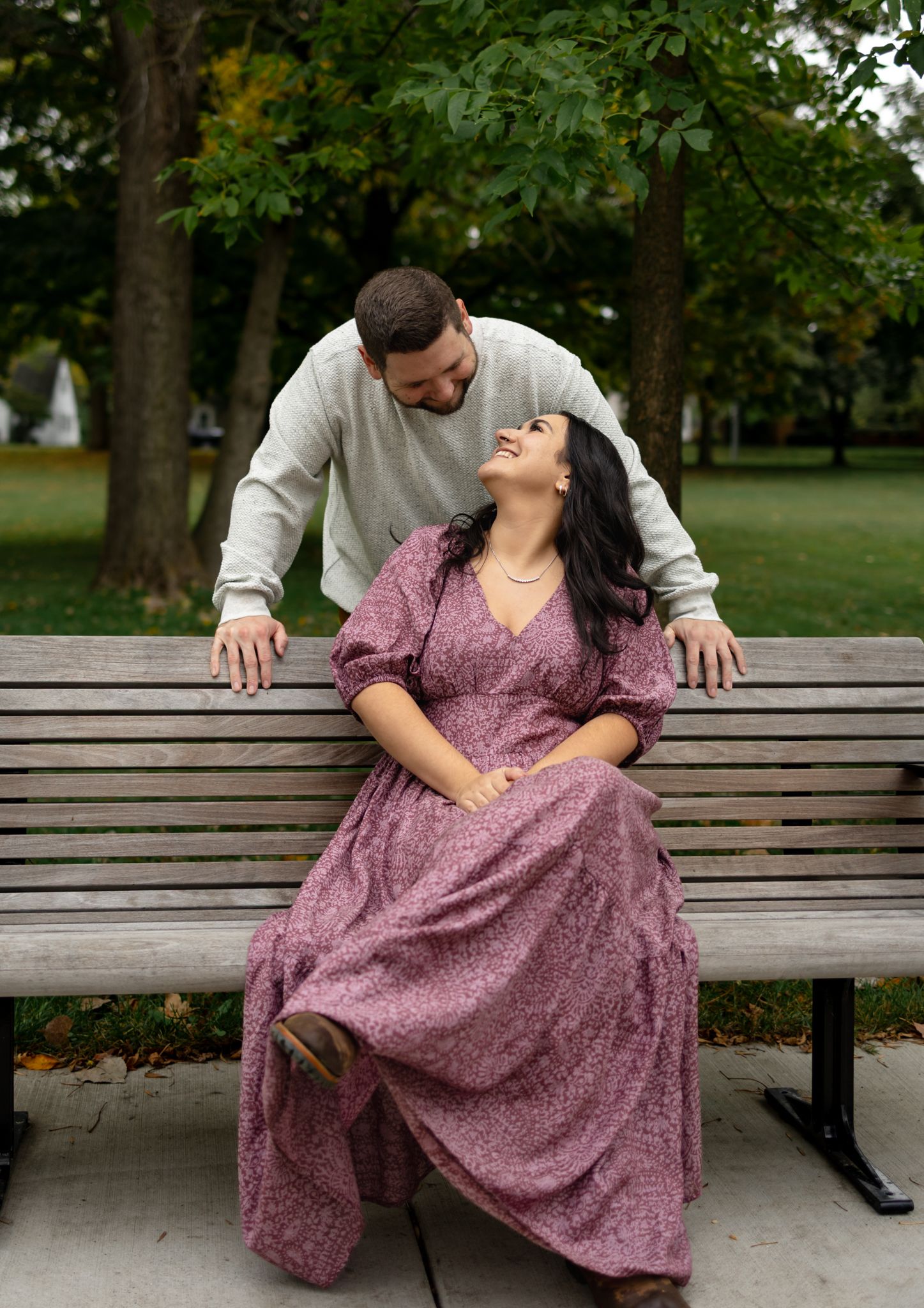 Couple sharing a romantic moment on a wooden park bench.