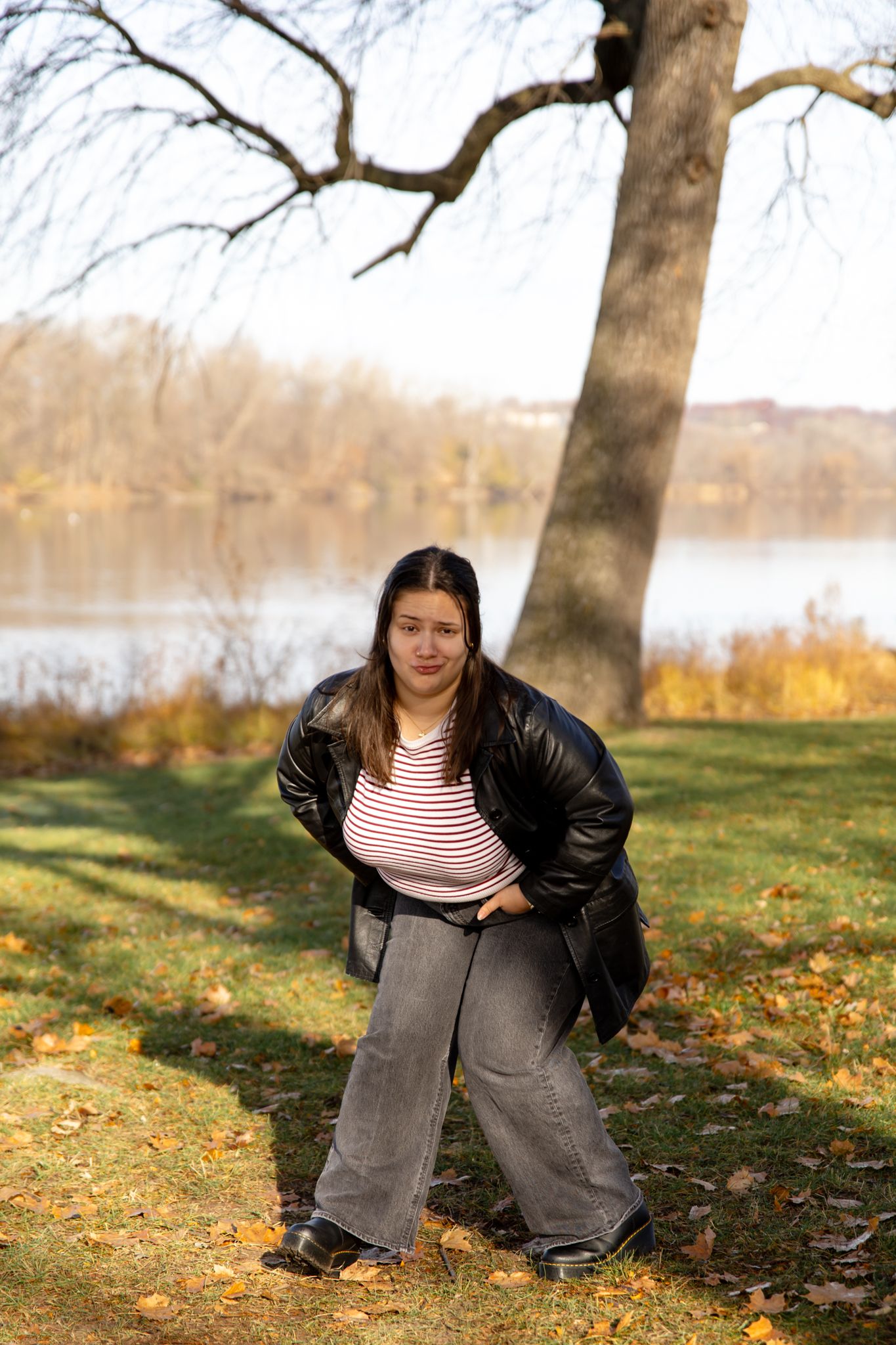 Progressive shots of someone in a black jacket performing stretches on fallen leaves.
