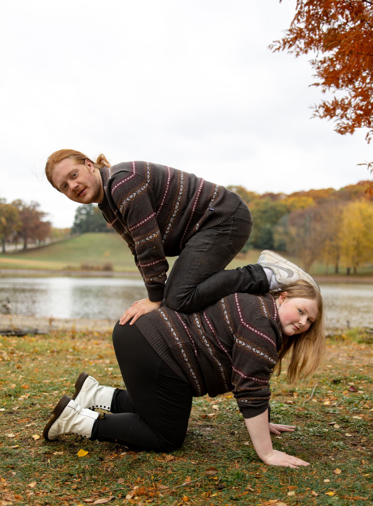 Playful sequence showing movement and poses on autumn ground near a lake.