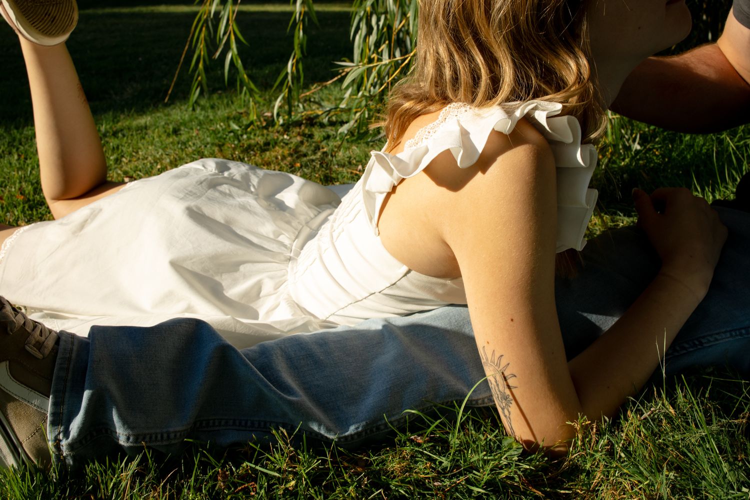 Intimate couples photography session in a natural outdoor setting with sunlight.