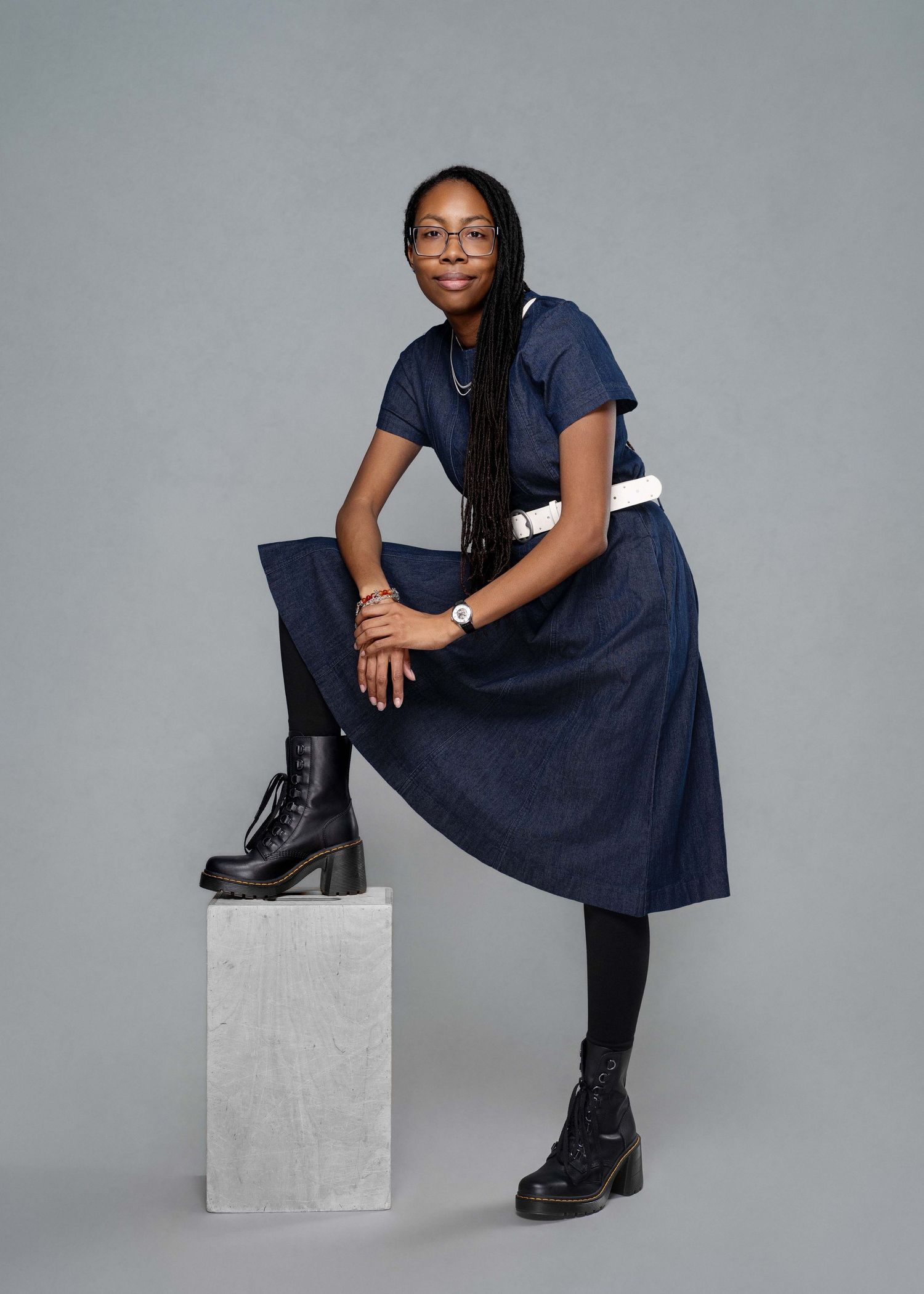 African American woman in a glamorous gold dress posing for a 29th birthday studio session.
