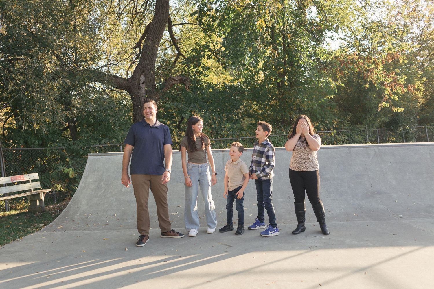 Une famille s'amusant sur une rampe de béton,  enveloppée d'une douce lumière naturelle.