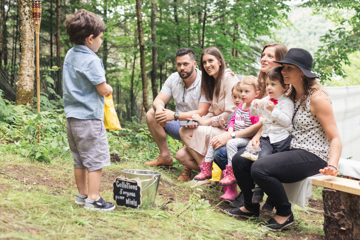Les invités du mariage assis sur un banc de bois.