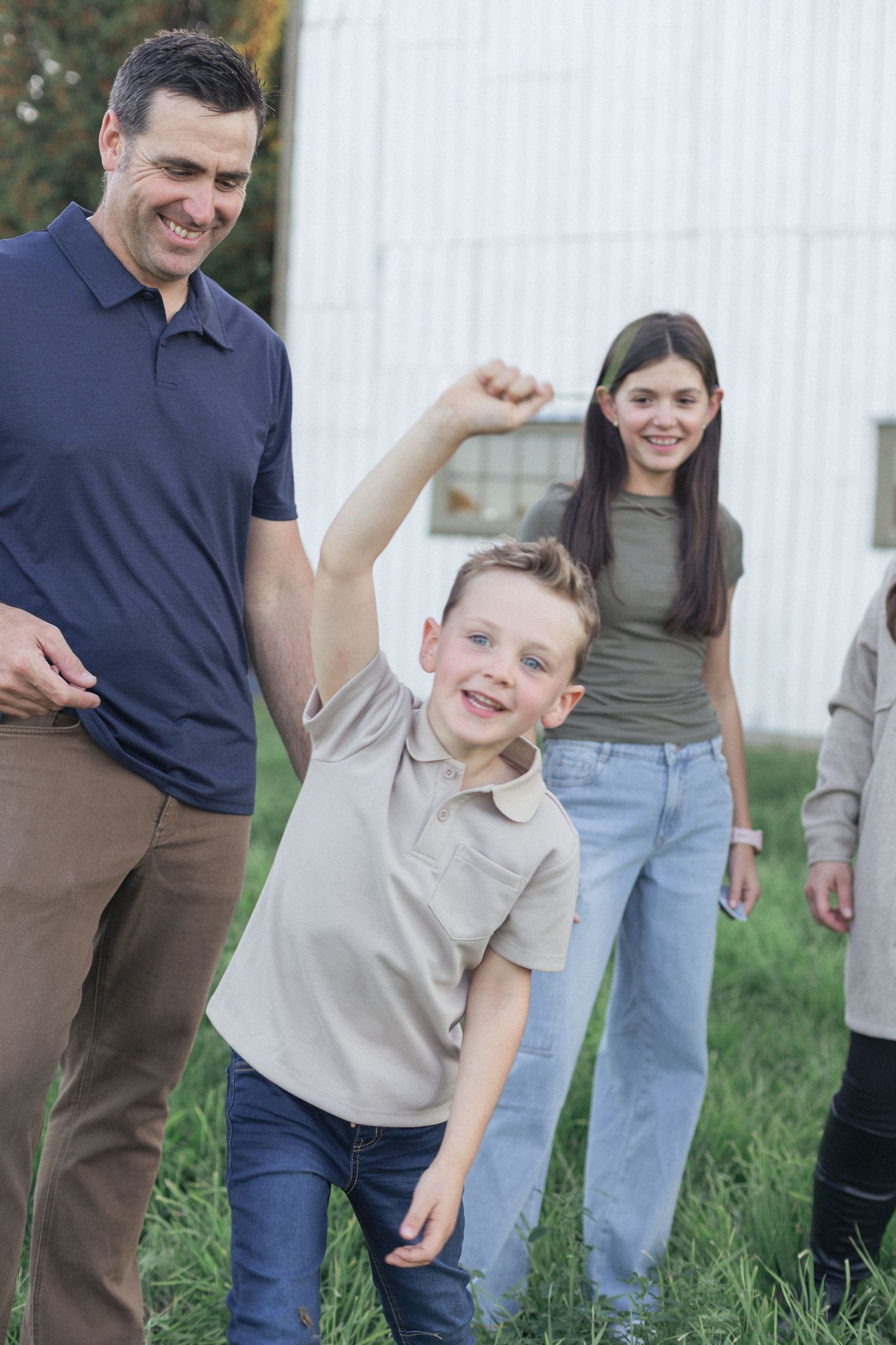 Des enfants et leur père s'amusant à l'extérieur.