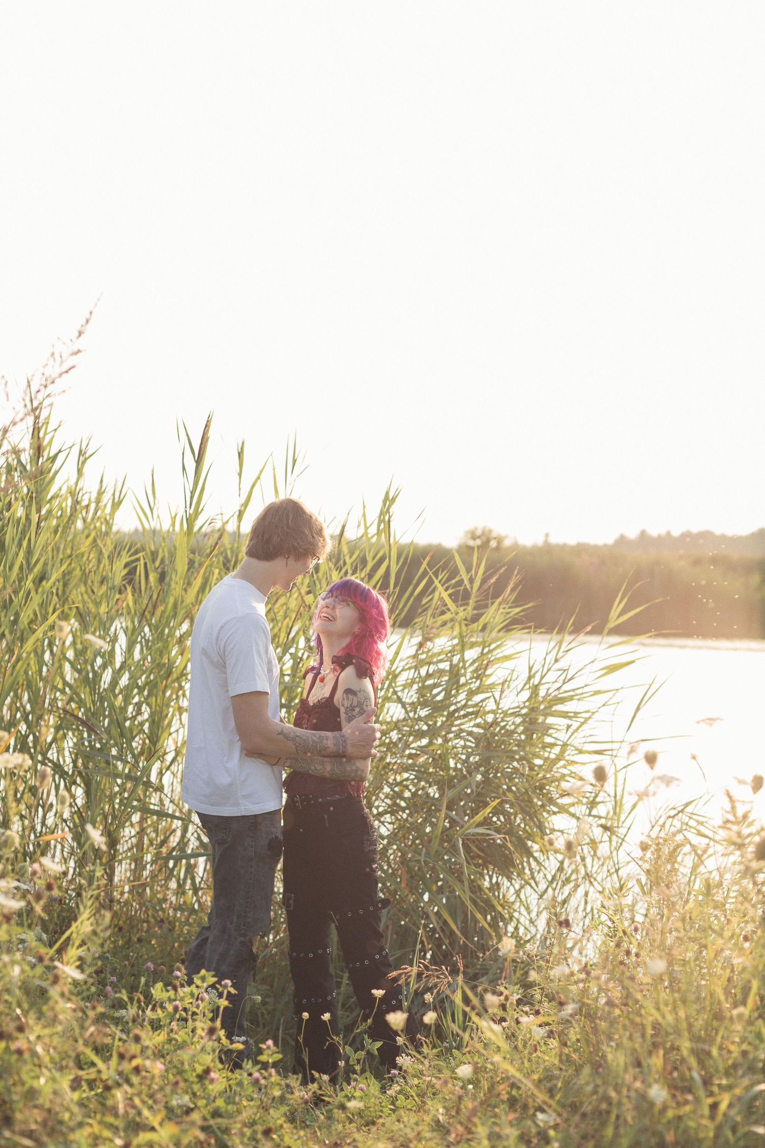 Couple qui se regarde près d'un lac au coucher du soleil.
