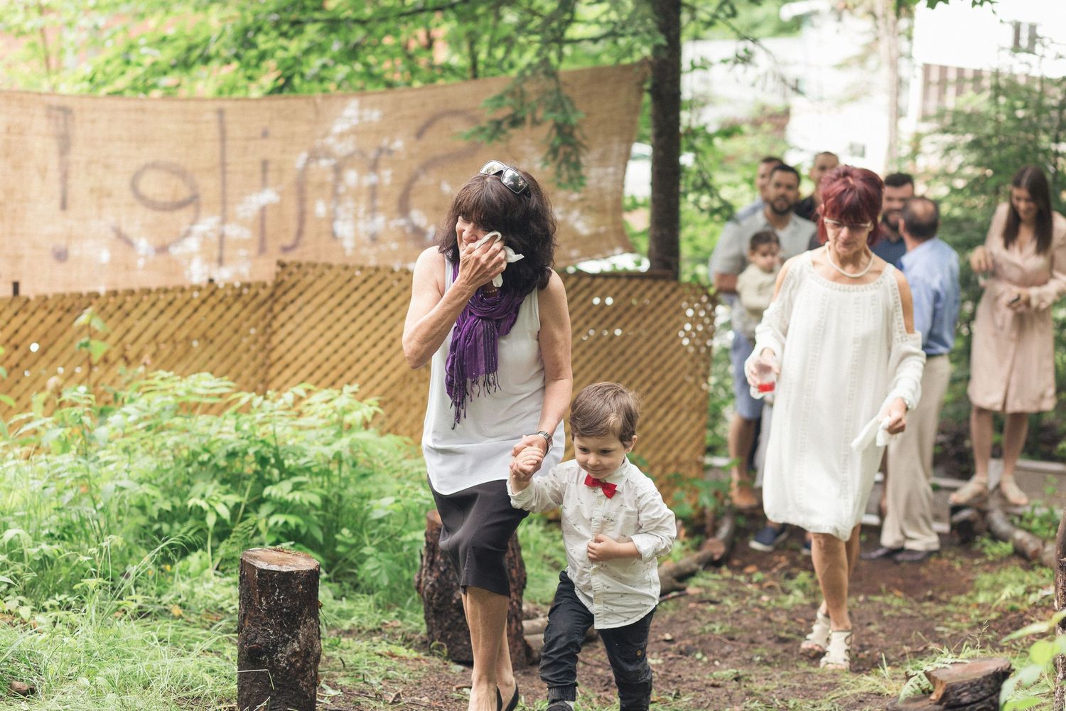 Les invités qui arrive au mariage surprise en forêt et se dirige vers leur banc.