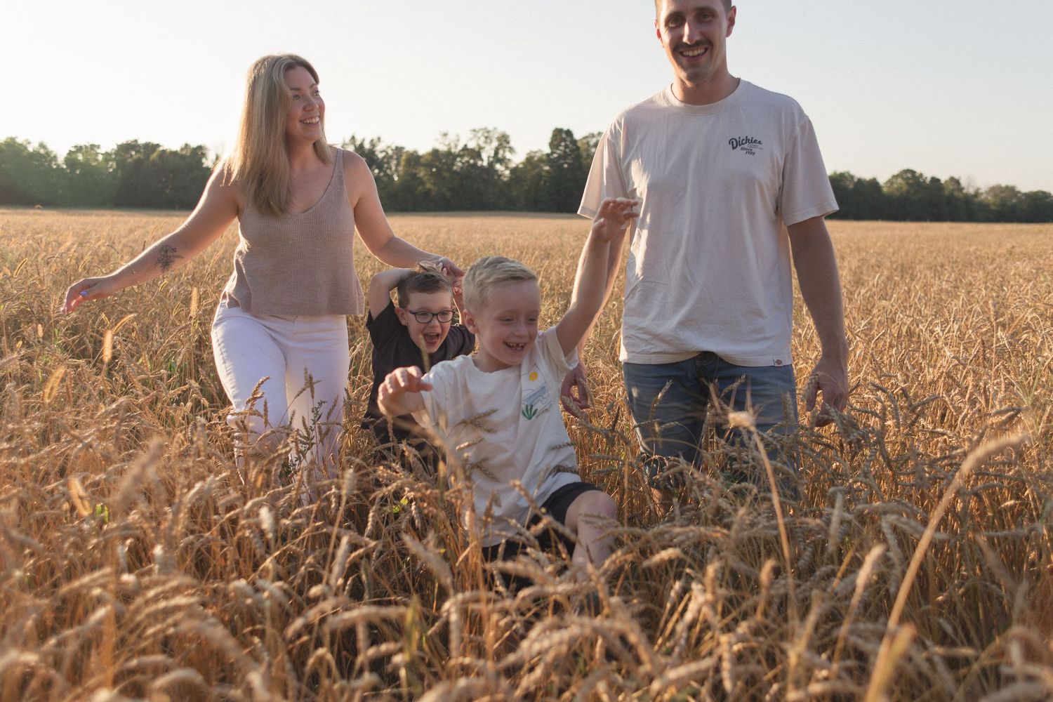 Une famille qui marche dans un champ doré.
