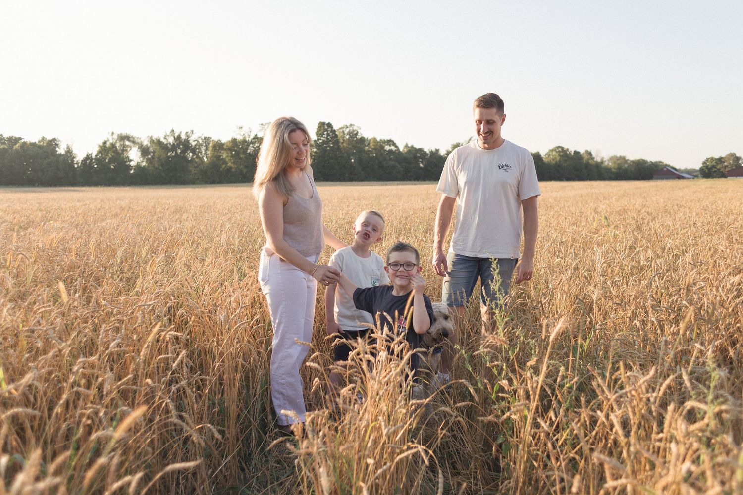 Portrait de famille dans un champ de blé doré, au coucher du soleil.