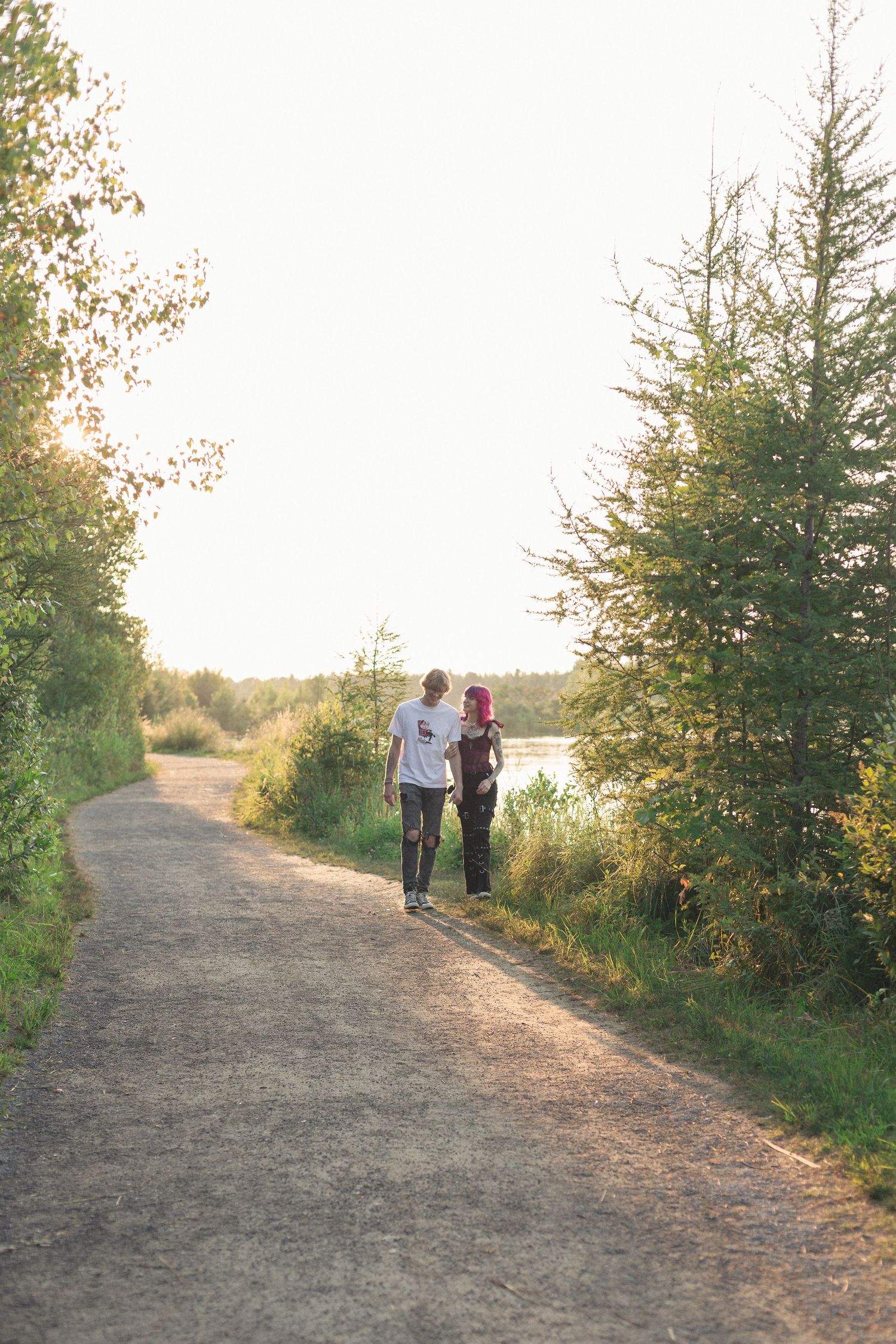 Un couple prenant une marche près du lac sous la lumière douce de fin de journée.