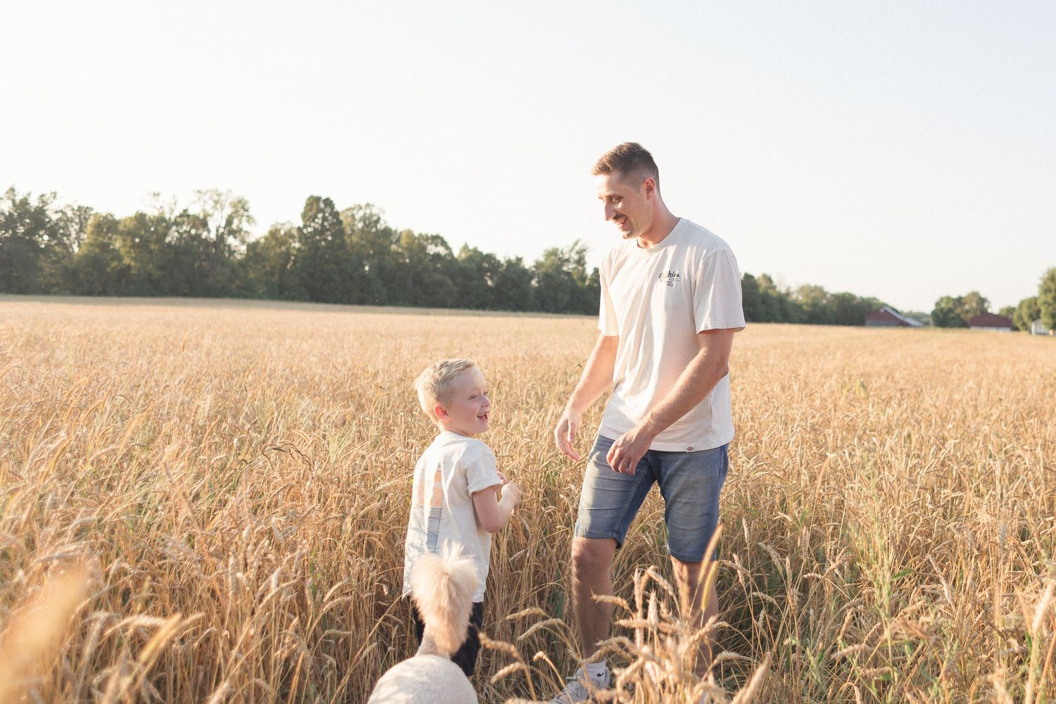 Un père et son fils s'amusant dans un champ de blé, en été.