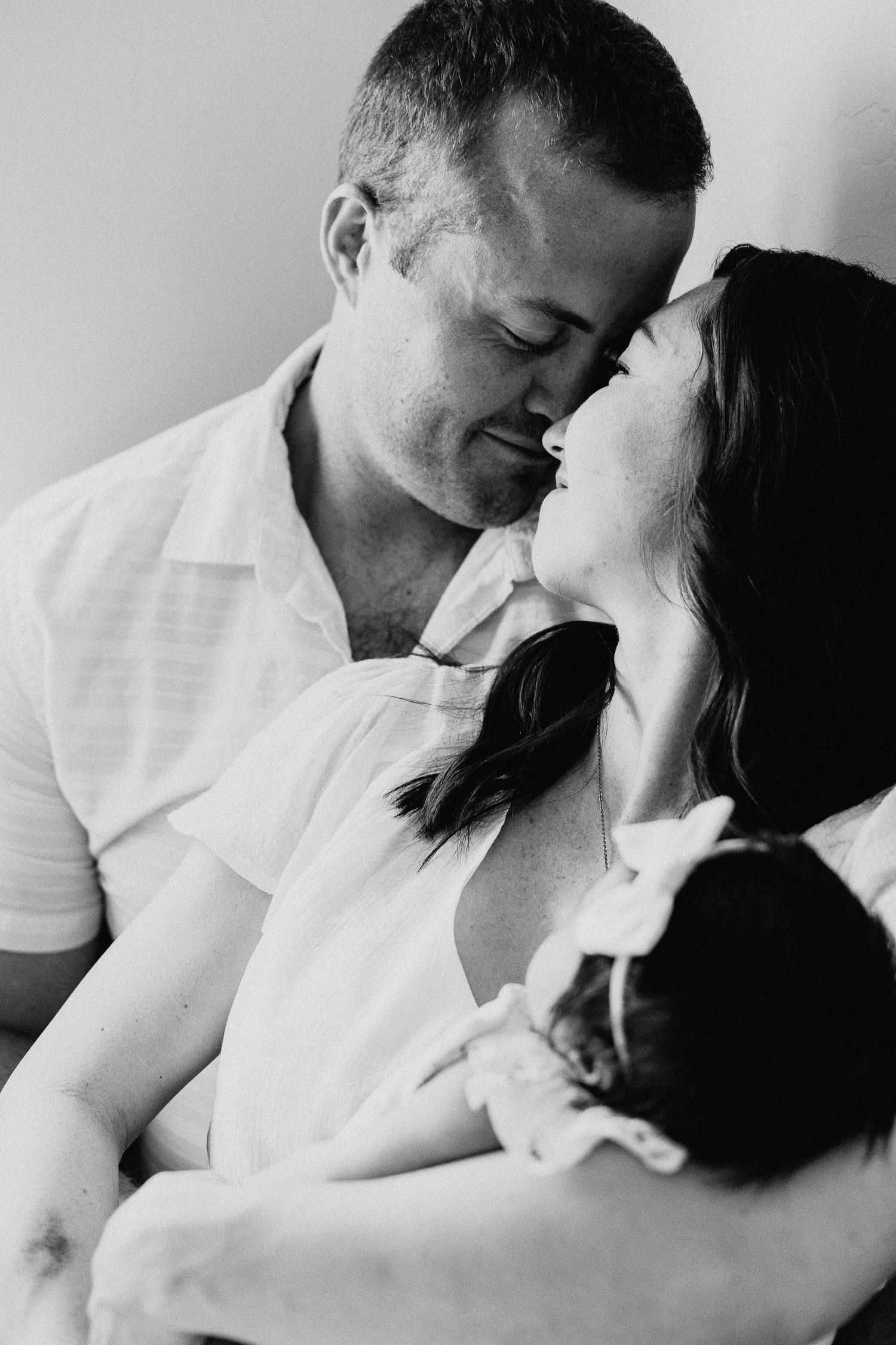 A romantic black and white photo series shows a couple in white shirts sharing tender moments and kisses.