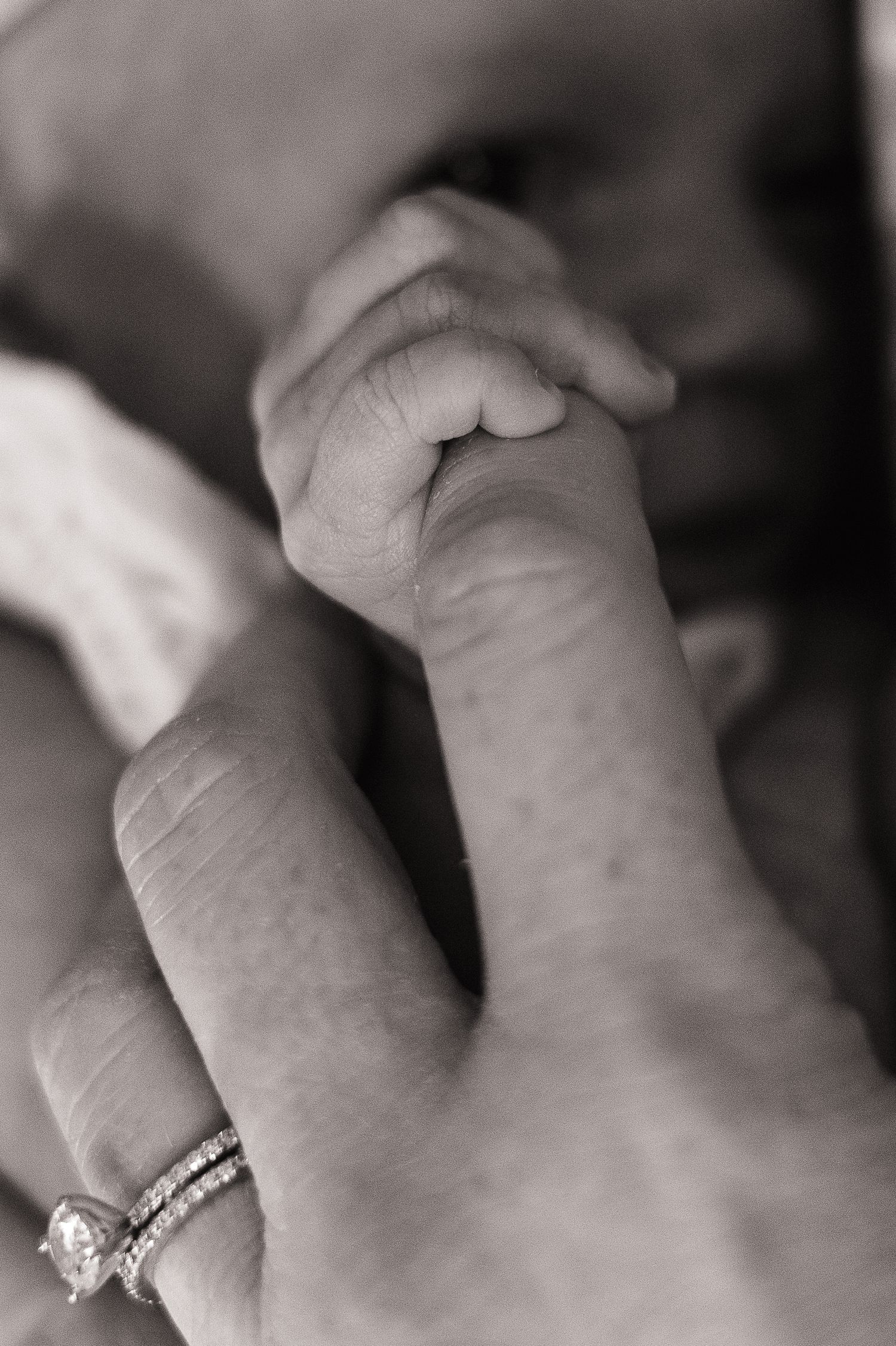 Close-up black and white photo sequence showing engagement ring on hand from multiple angles.