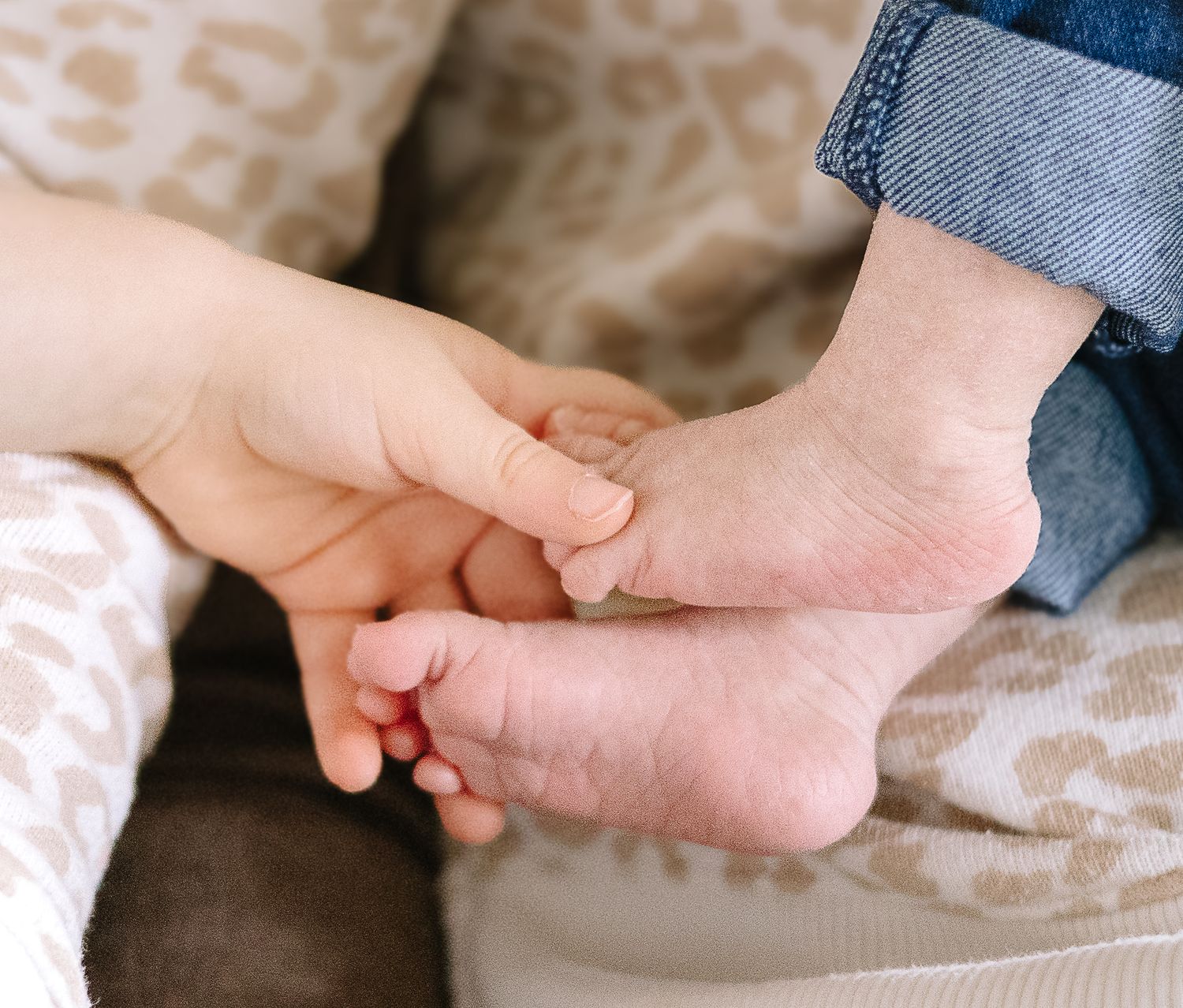 Close-up view of hands gently massaging a bare foot during a relaxing spa treatment.