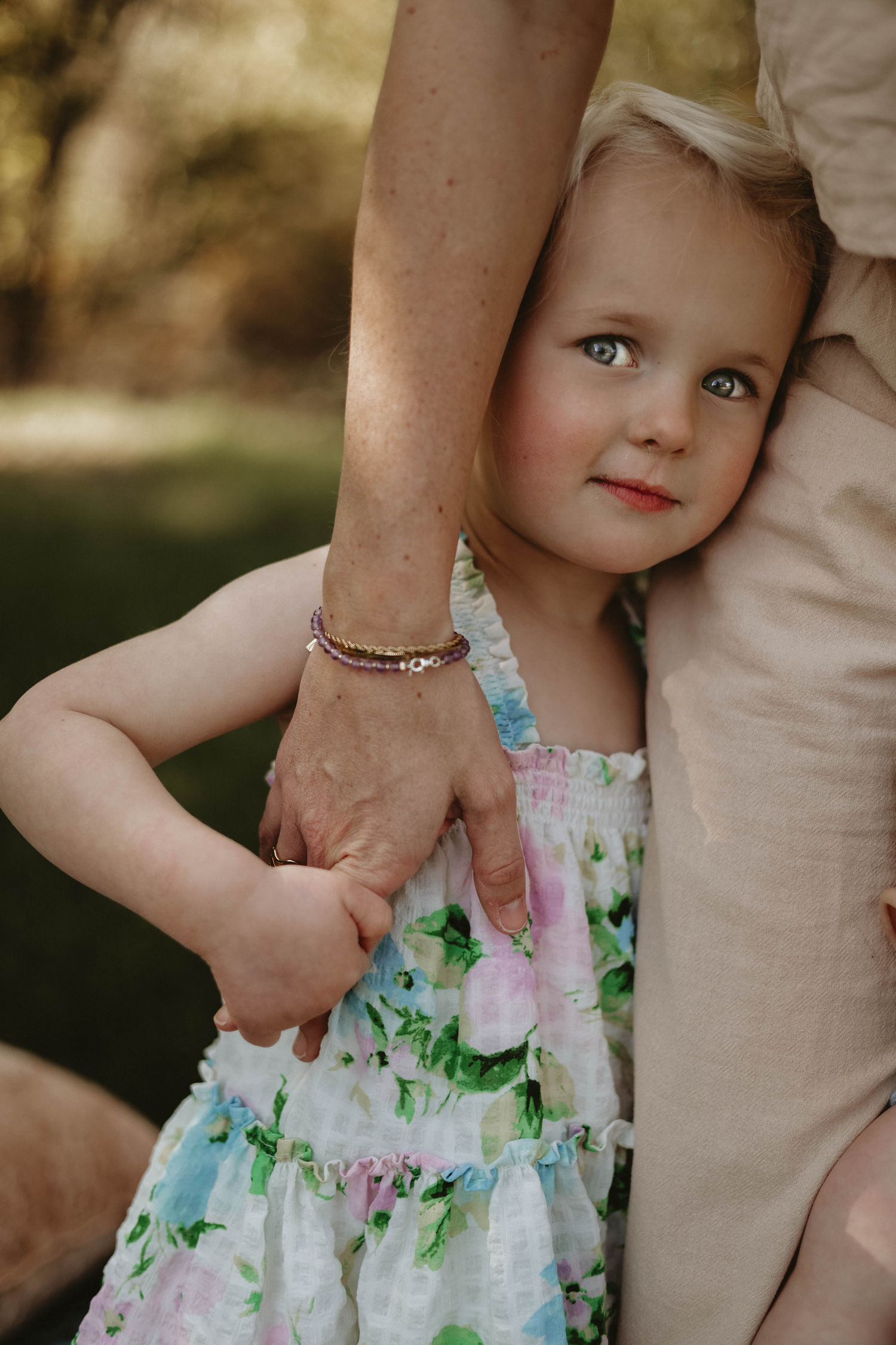 Close-up portrait showing details of floral dress and gentle interaction.