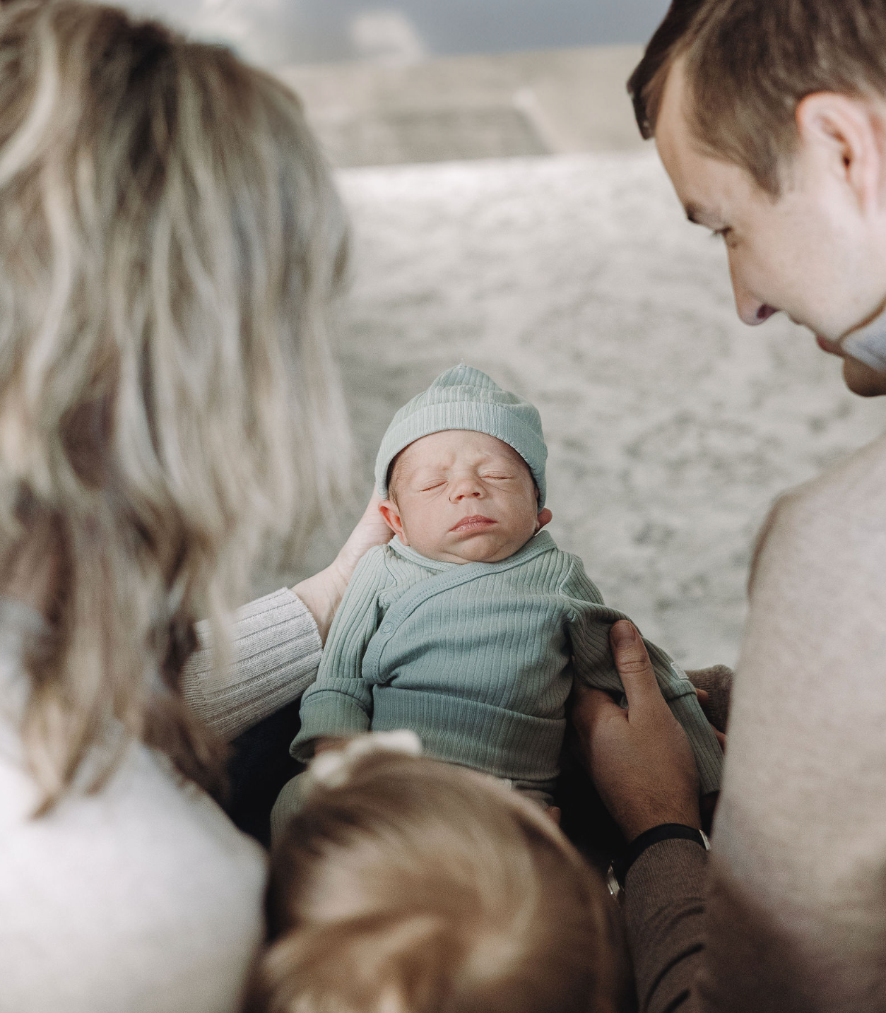 Three candid images show tender moments capturing a sleeping baby in soft mint green clothing.