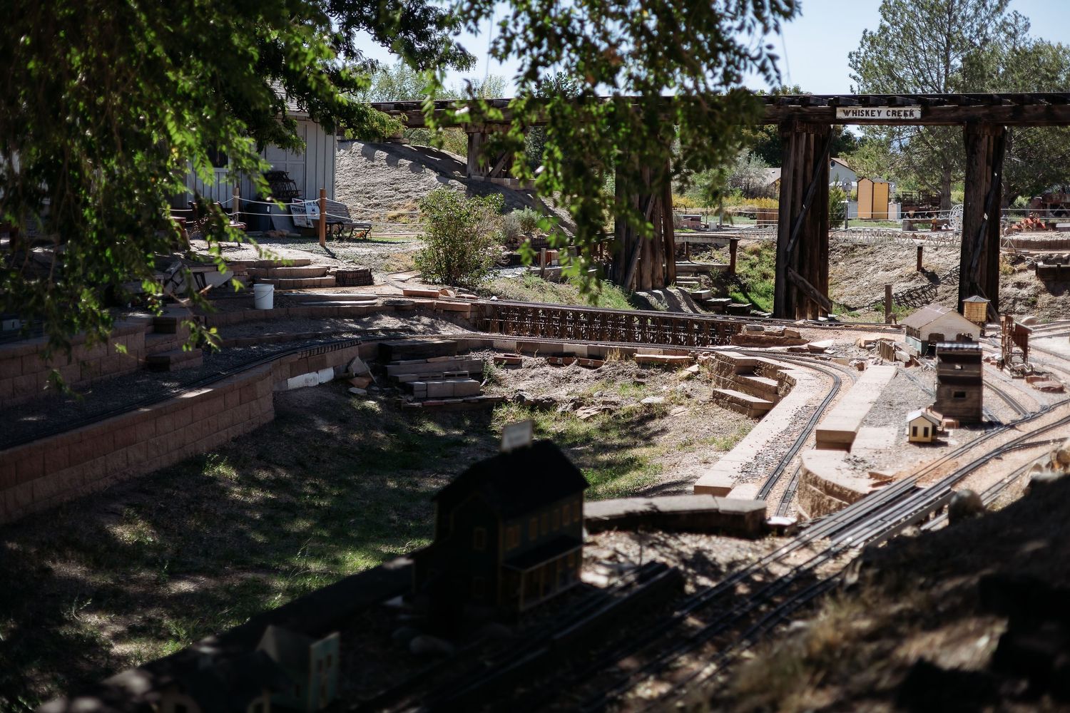 A series of construction and landscaping photos showing wooden beams, stone paths, and outdoor work in progress.