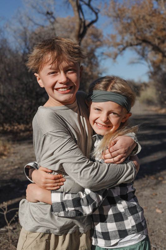 Brothers sharing a warm embrace while outdoors at the Connected Lakes, Grand Junction, Colorado.