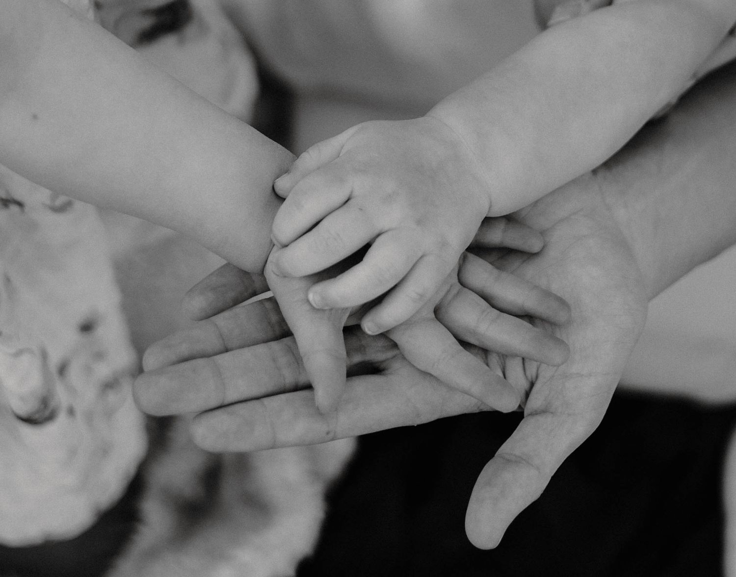 Close-up black and white photo of hands touching and connecting.