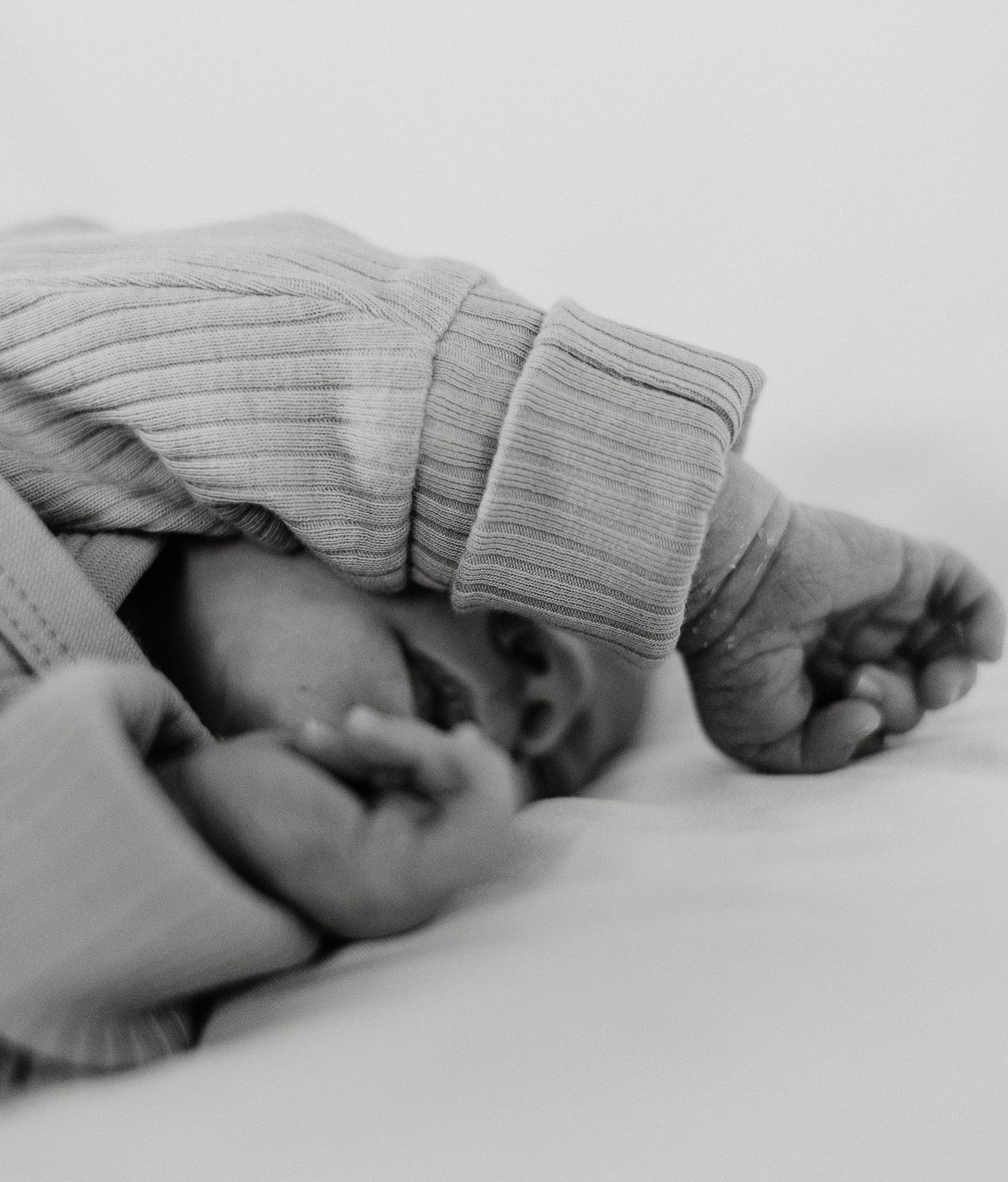 A black and white close-up sequence showing hands wearing a gray striped glove folding into different positions.