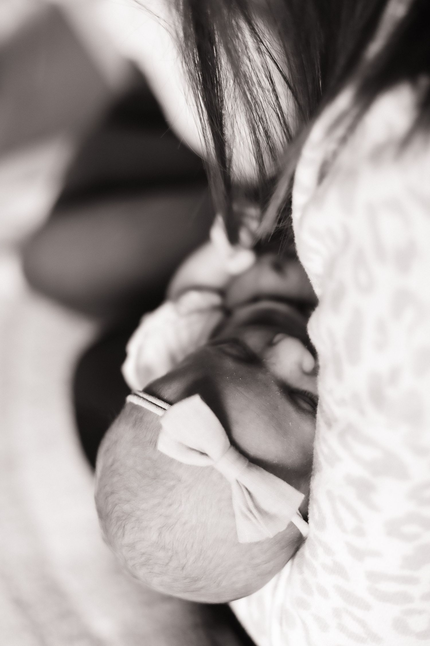 Close-up black and white image of a person drinking from a white paper cup.