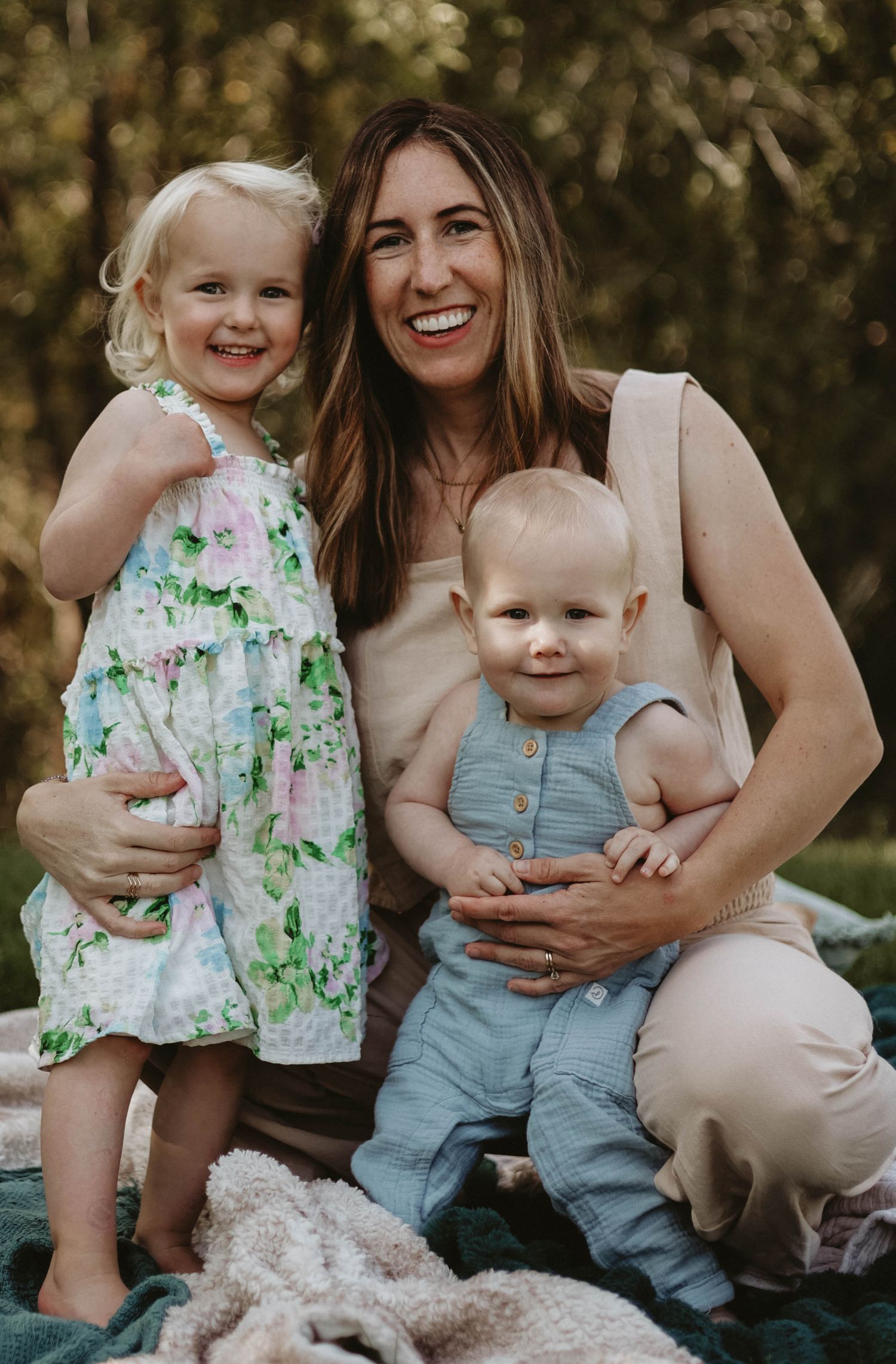 Happy family moment captured during outdoor photo session on blanket.