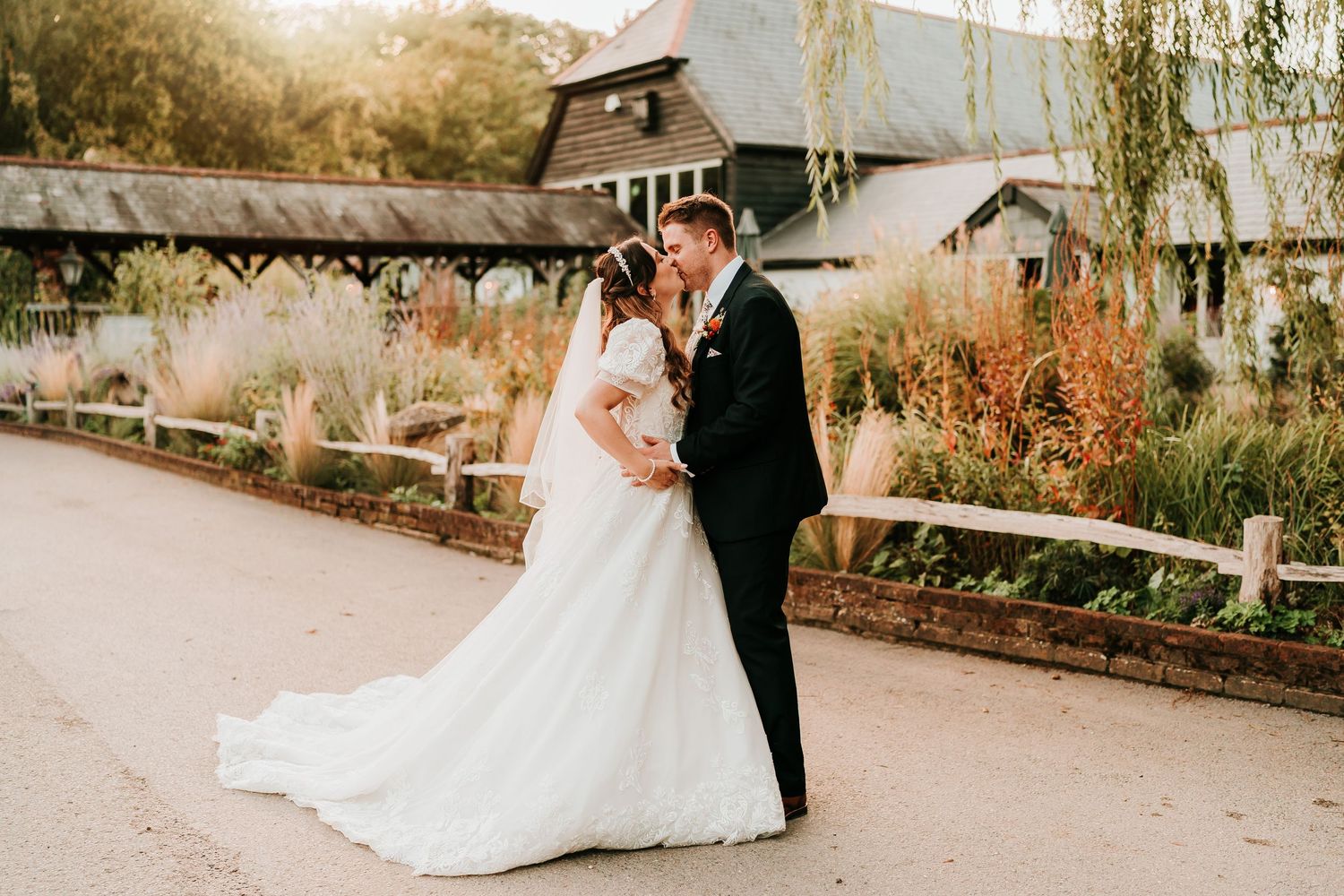Bride and groom in the golden Hampshire evening light at Kimbridge Barn.