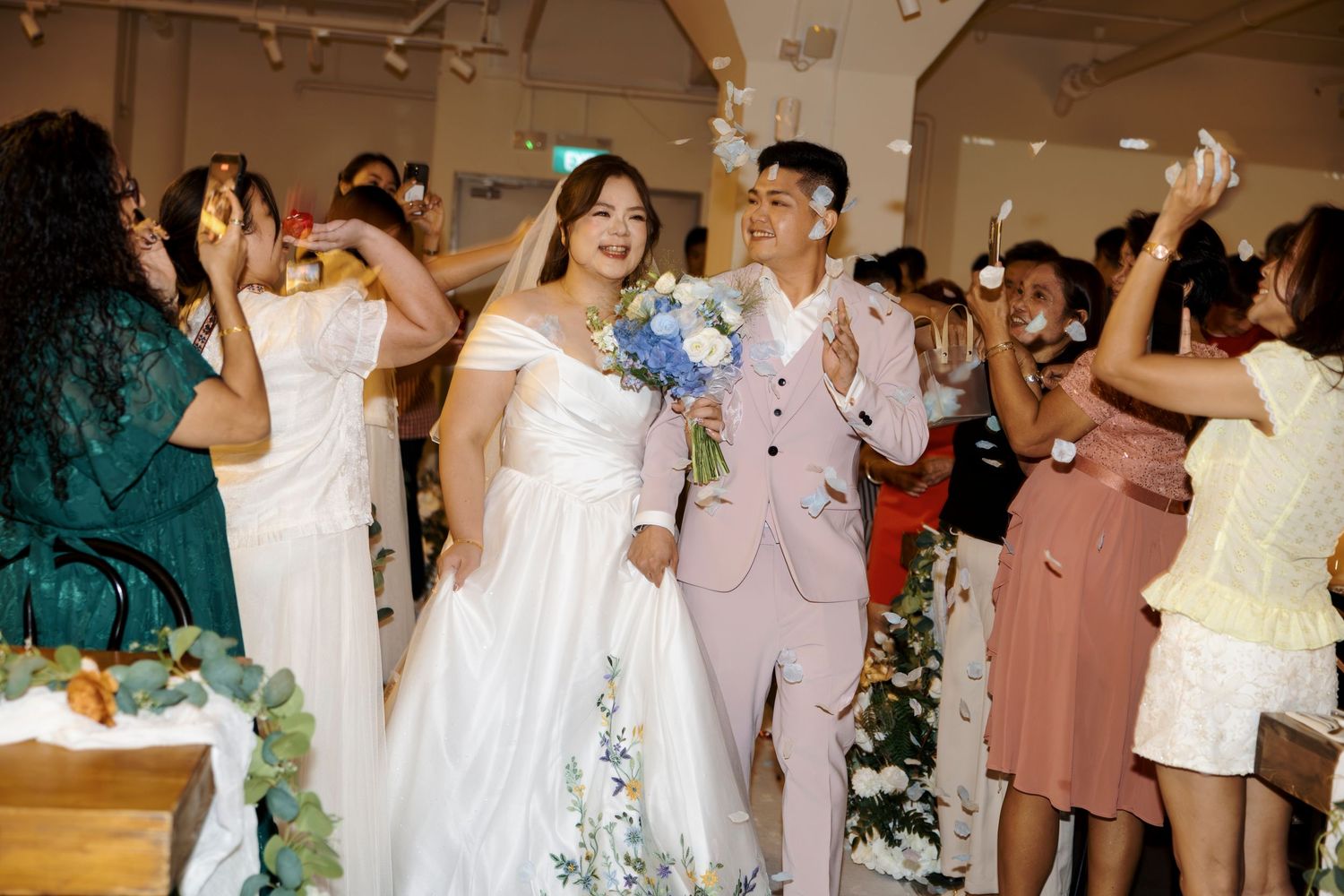 Guests cheering as the couple march into their wedding banquet in Singapore