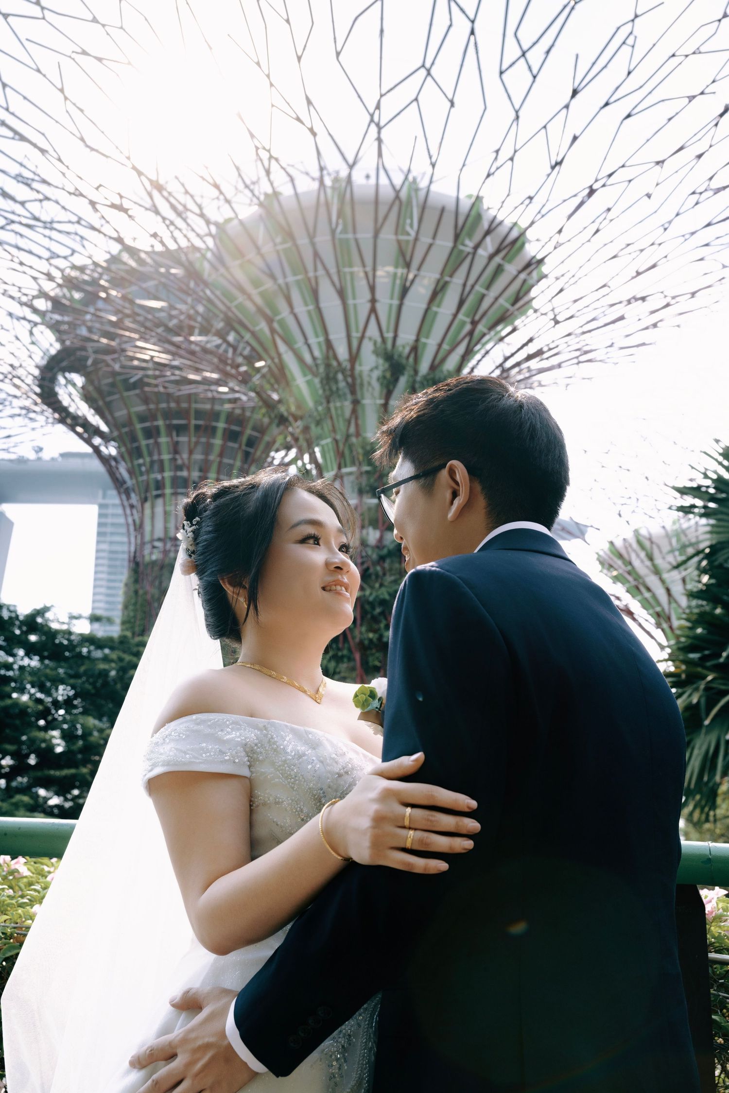 Bride and groom share a romantic moment at Gardens by the Bay, Singapore, with Supertree Grove in the background.