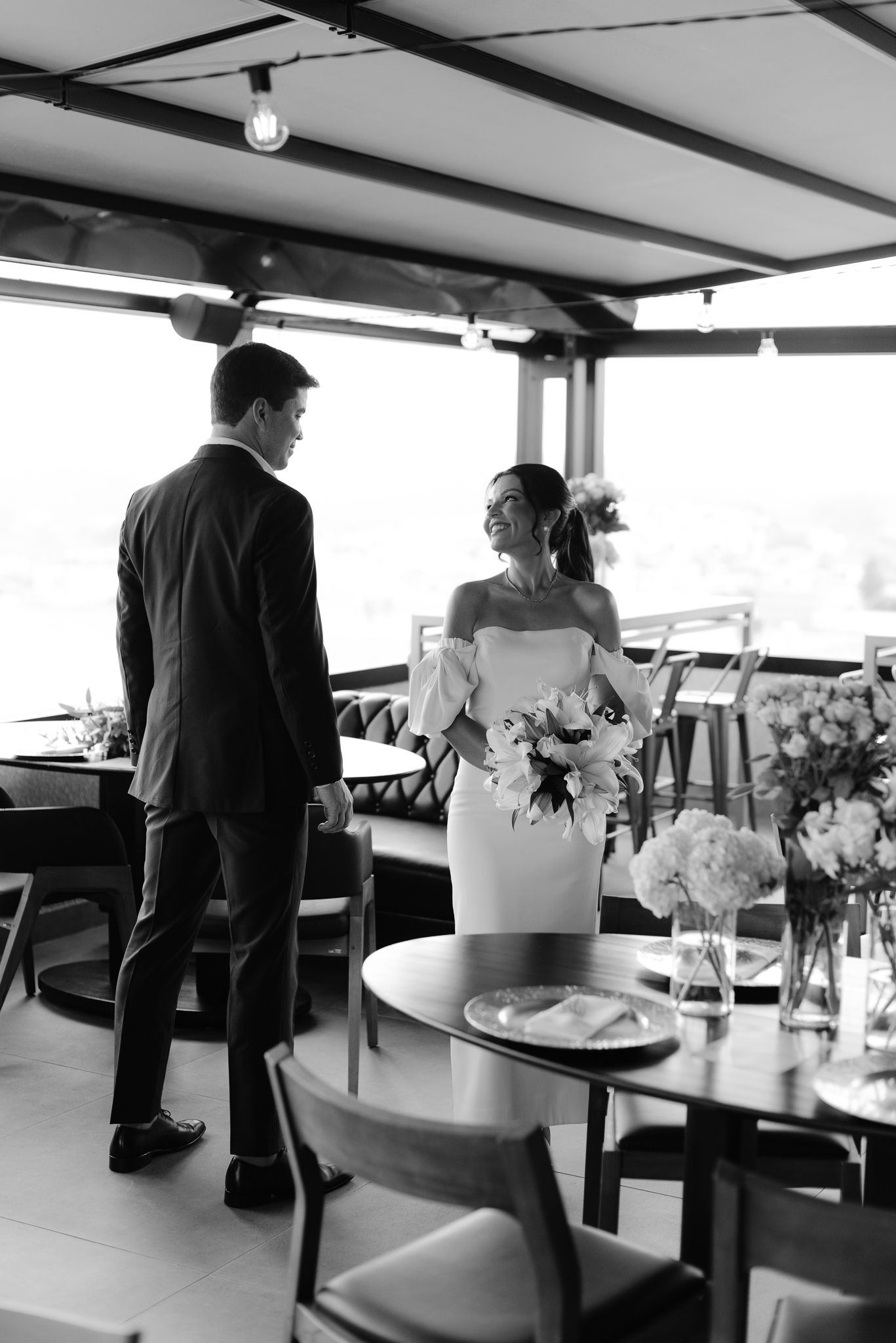 Black and white reception venue with tables and chairs set up for a wedding celebration.