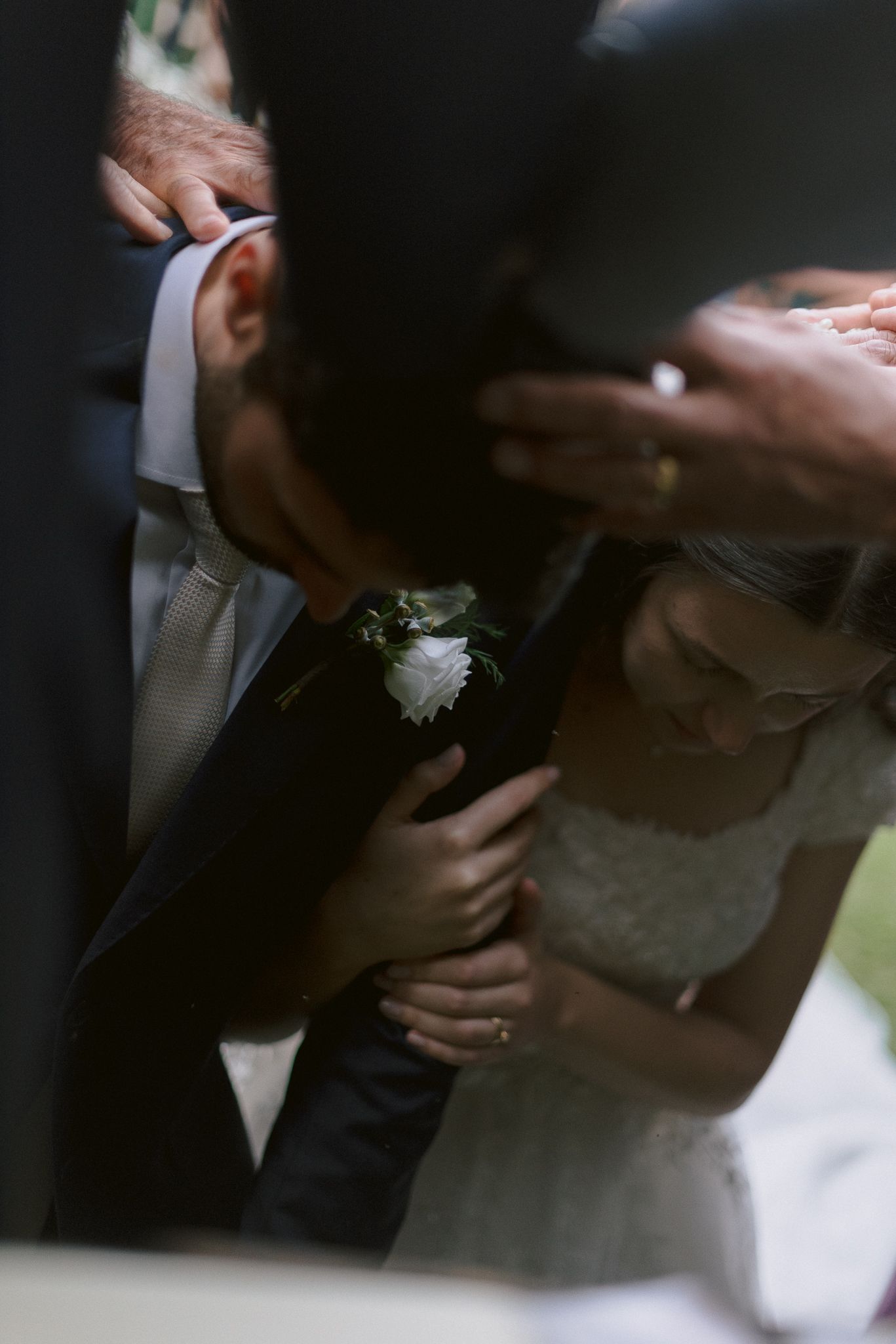 Close-up views of hands holding each other during a wedding ceremony, focused on the rings and intimate gestures.