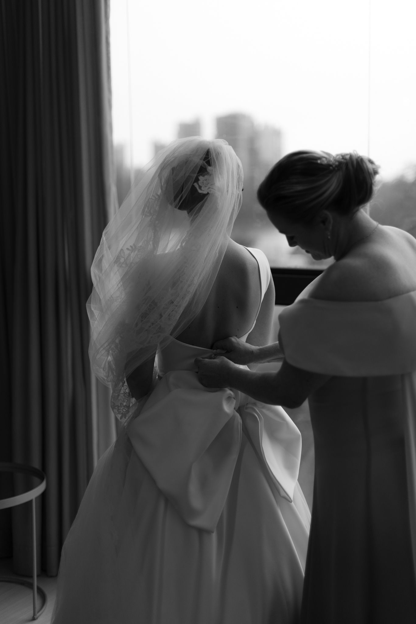 Intimate black and white getting ready moment with flowing wedding dress.