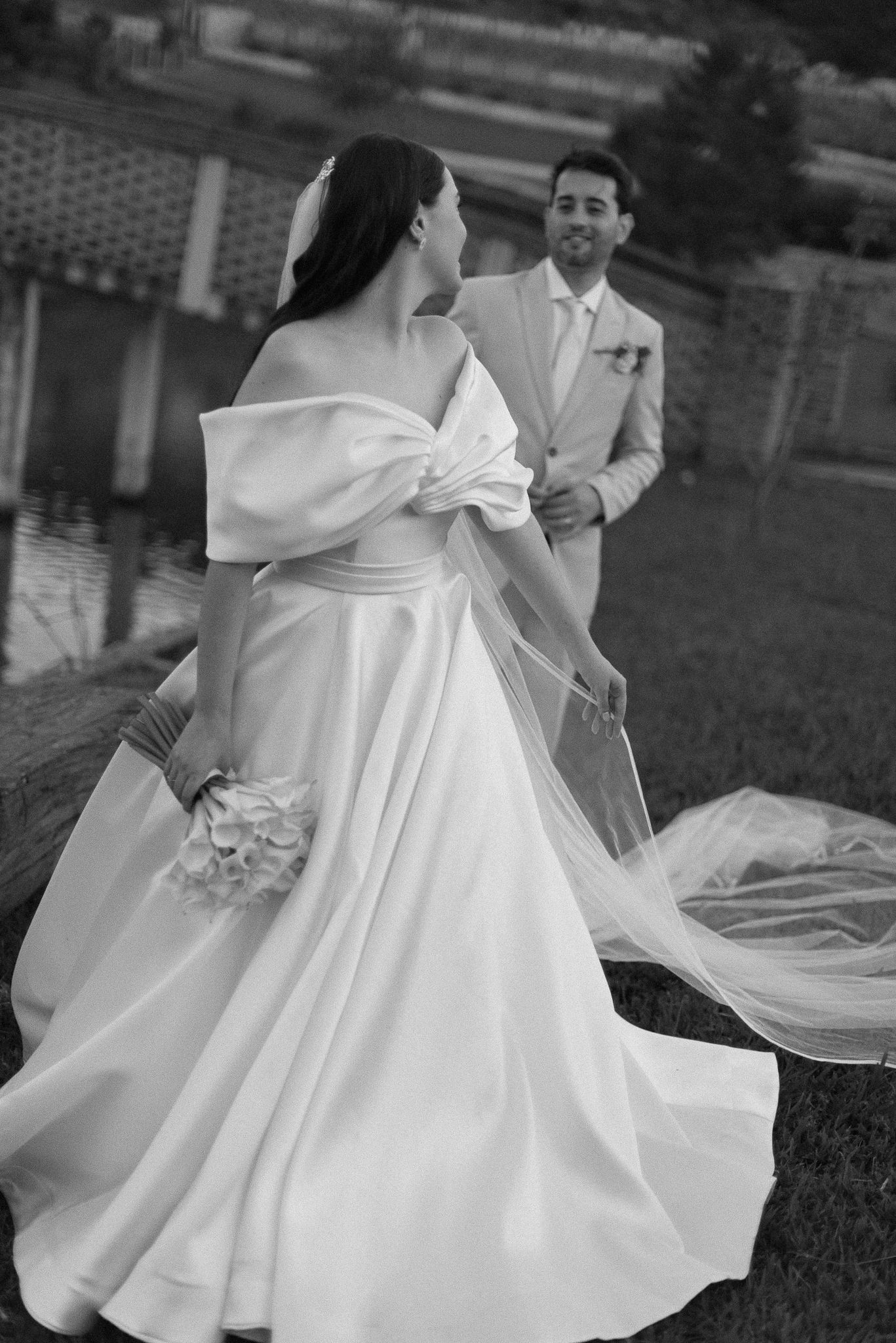 A sequence of black and white photos showing the elegant twirl of a white wedding dress on a grassy lawn.