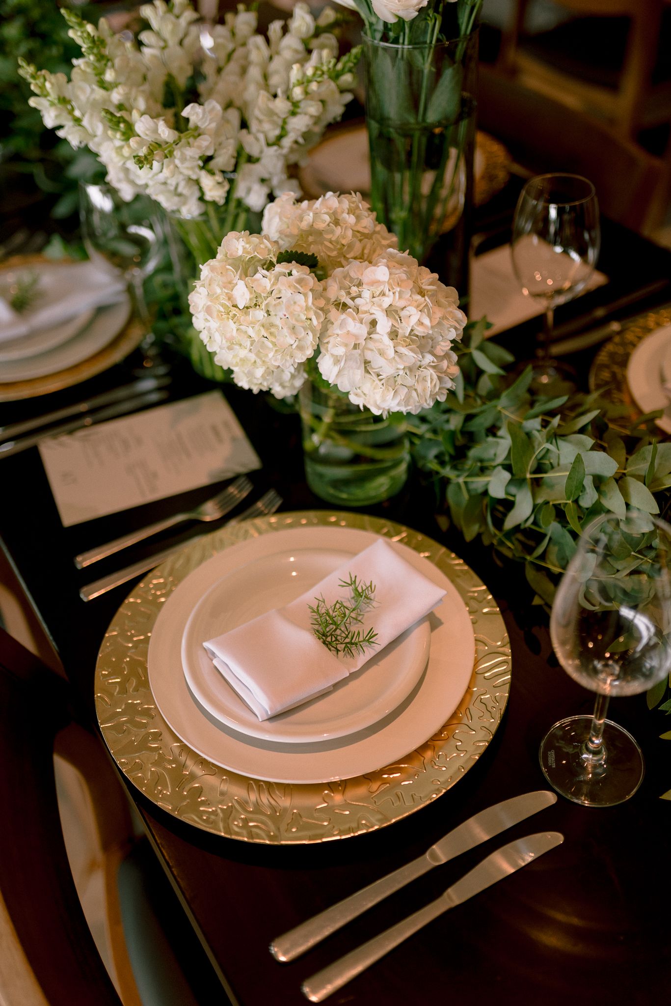 Romantic table setting with blush plates, gold chargers and hydrangea centerpiece.