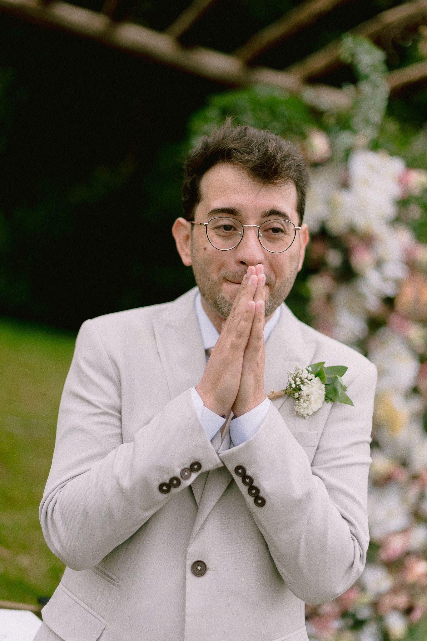Four sequential emotional expressions showing reactions and hand gestures against a blurred floral background.
