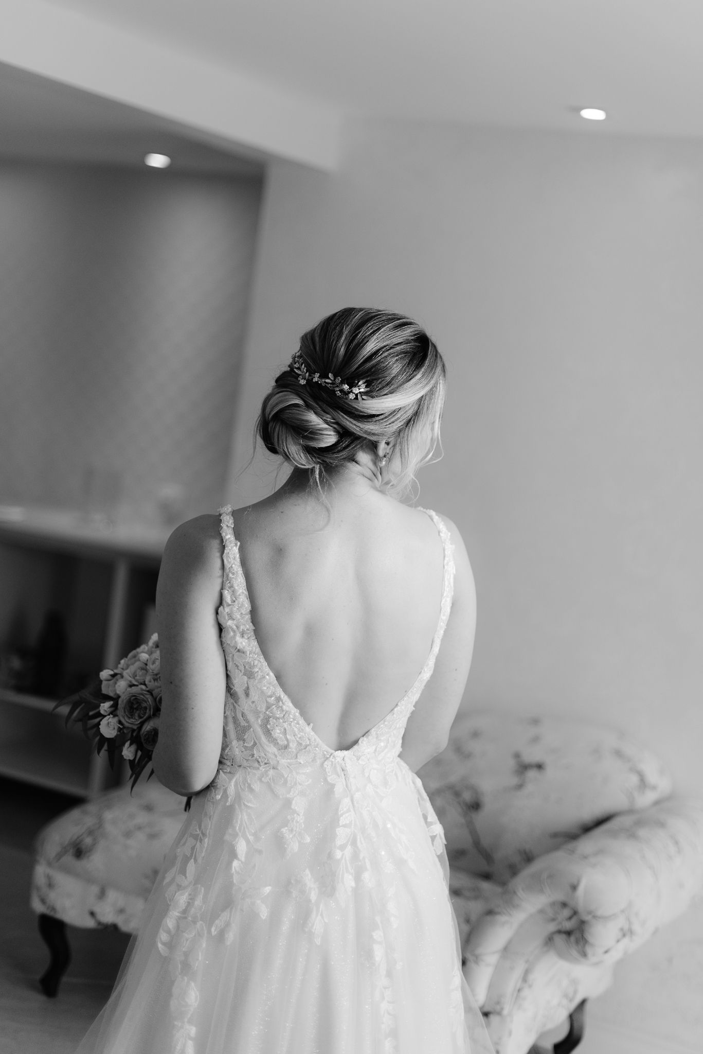 Black and white portrait of wedding dress details showing intricate lace and elegant back design.