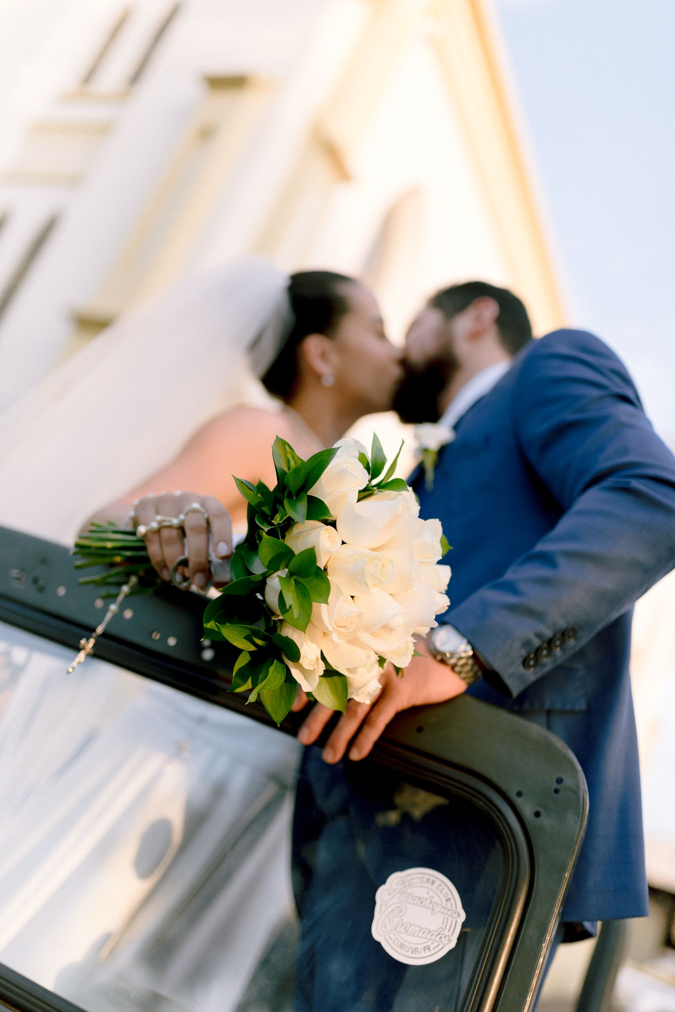 White flowers delicately drape over a box camera during an cientmatic photo shoot.