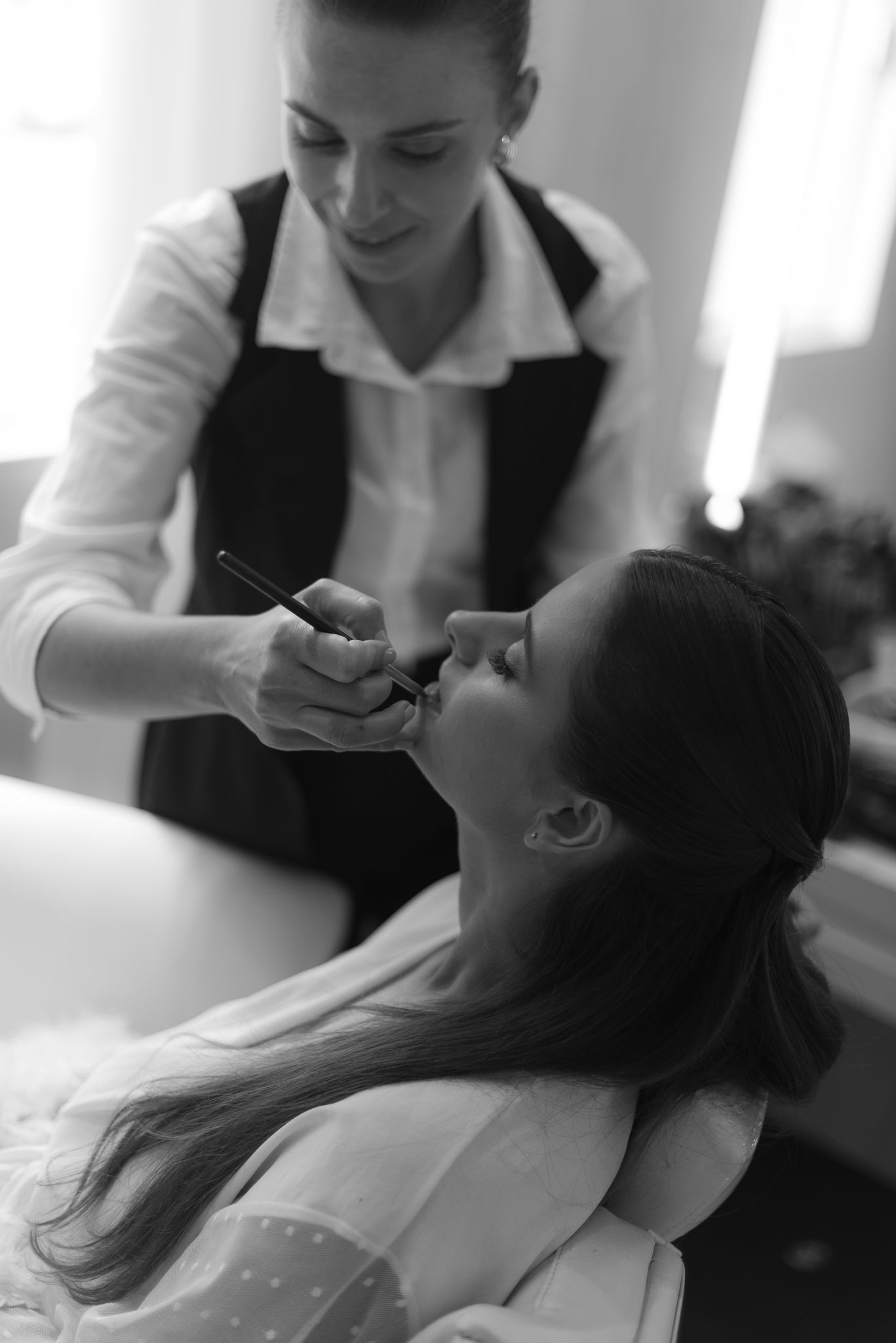 A series of black and white photos showing a beauty treatment being performed at a spa or salon.
