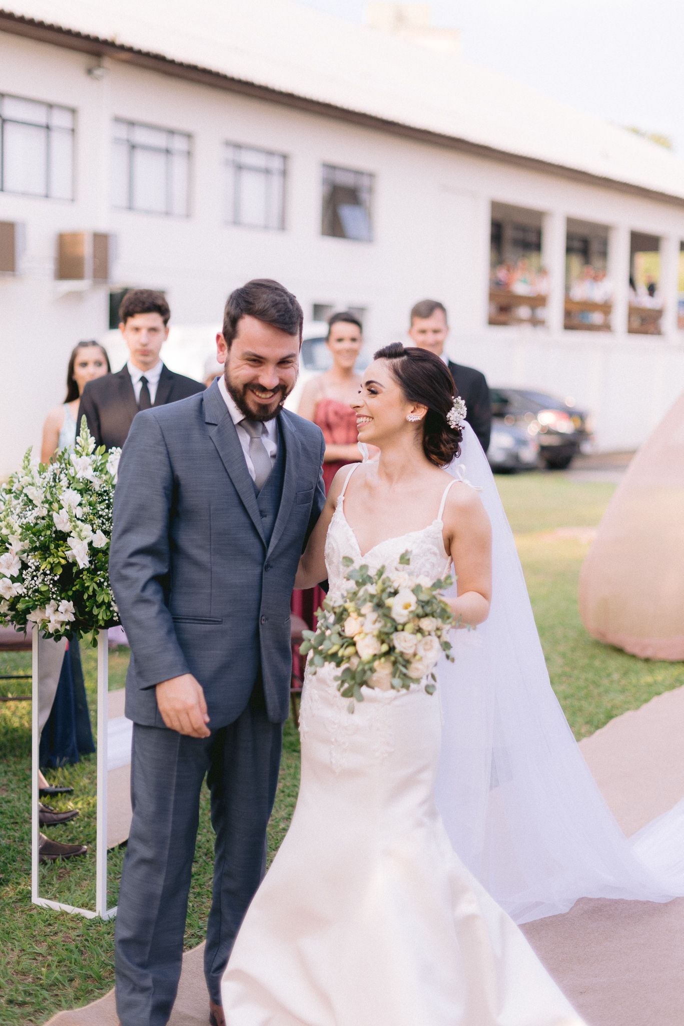 Joyful wedding celebration outdoors with wedding party in formal attire.