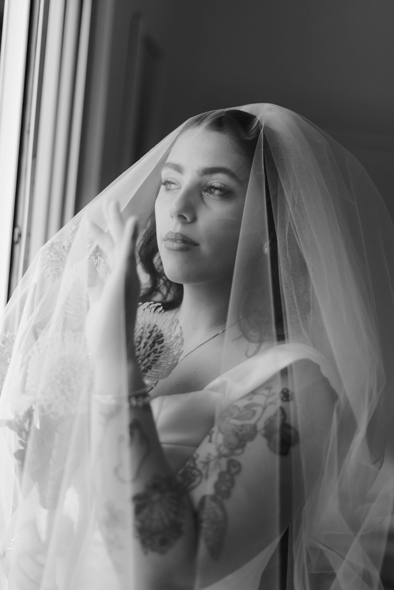 Artistic black and white portrait series of bride wearing delicate veil.