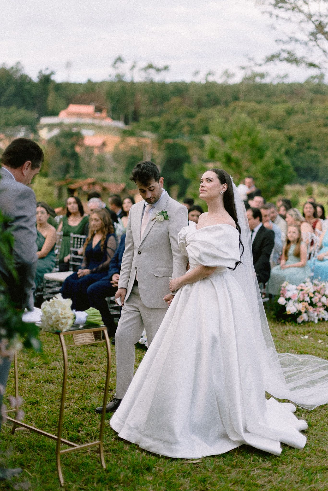 Wedding celebration on a hillside with elegant decor and guests in attendance.