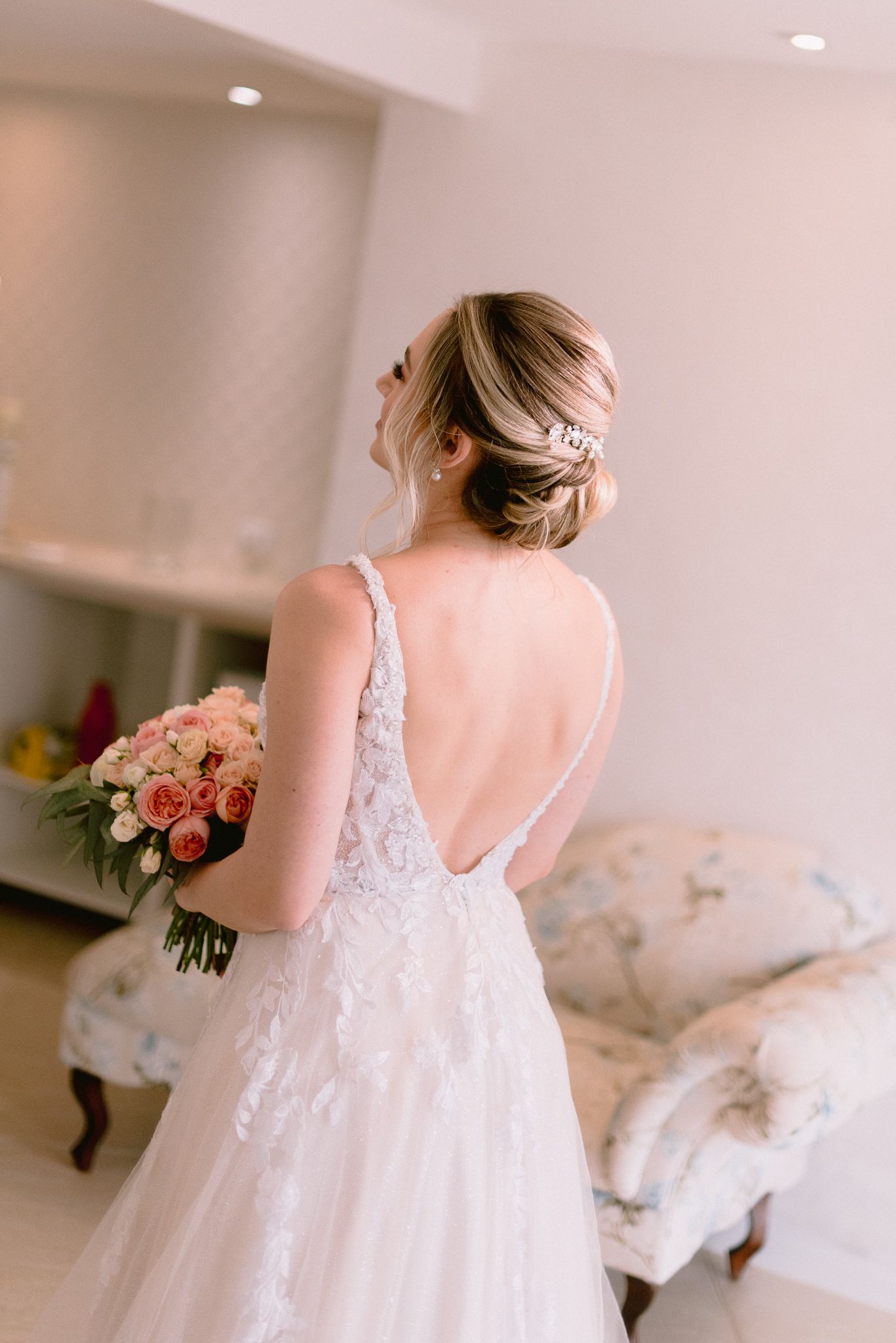 Delicate lace wedding dress with open back design and romantic flowing silhouette.
